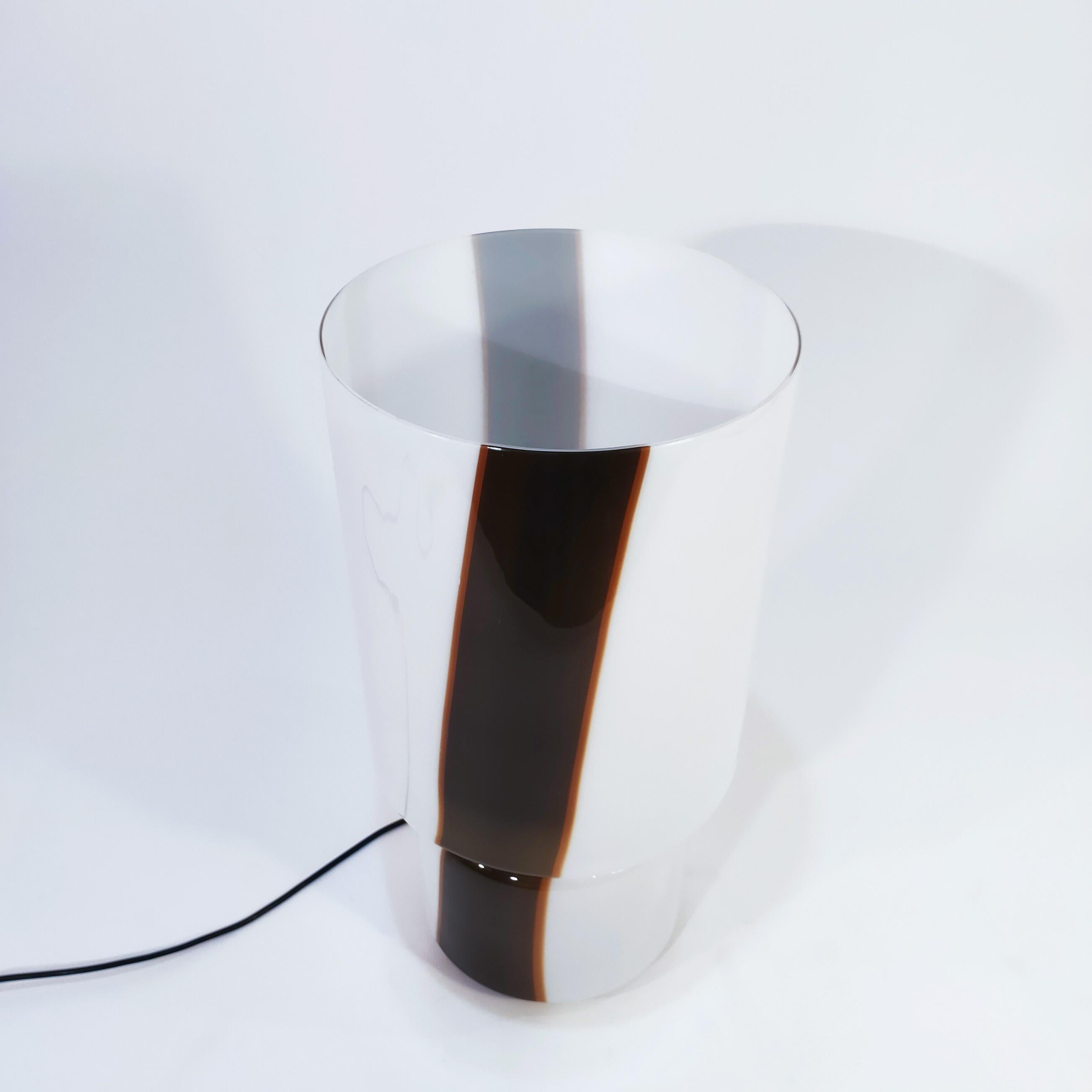 Hergestellt von Leucos, Italien, 1970er Jahre. Handgefertigt aus einem Stück weißem, mundgeblasenem Murano-Glas mit zwei Streifen auf gegenüberliegenden Seiten in Braun-, Olivgrün- und Orangetönen. Sie ist mehr als nur eine Lampe, sie ist ein