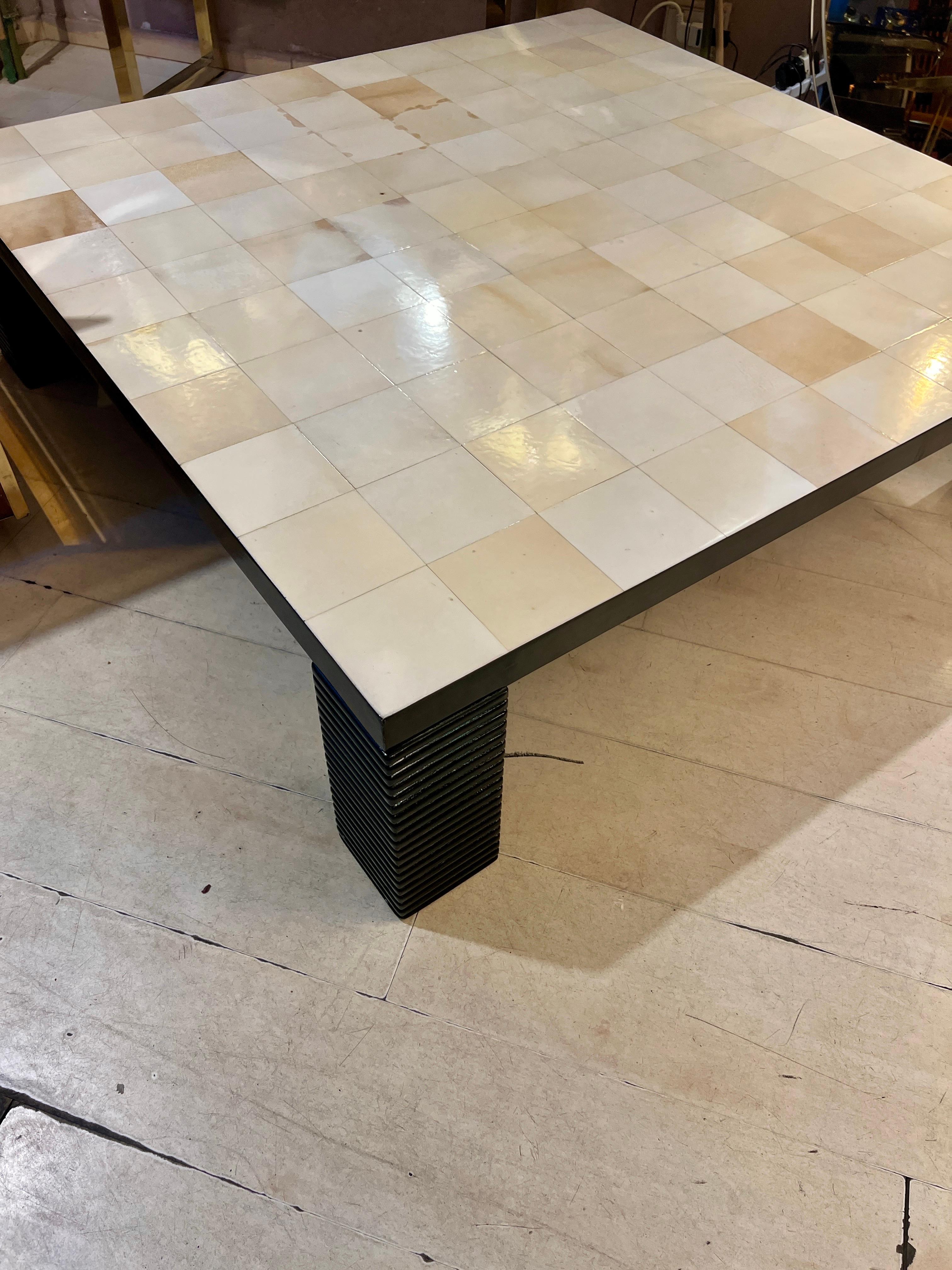 Table basse carrée en papier parchemin vintage Bigli.
Le plateau présente une surface à motifs géométriques composée de carreaux de parchemin naturel enveloppés individuellement et sélectionnés pour contraster la richesse du ton et du grain de ce