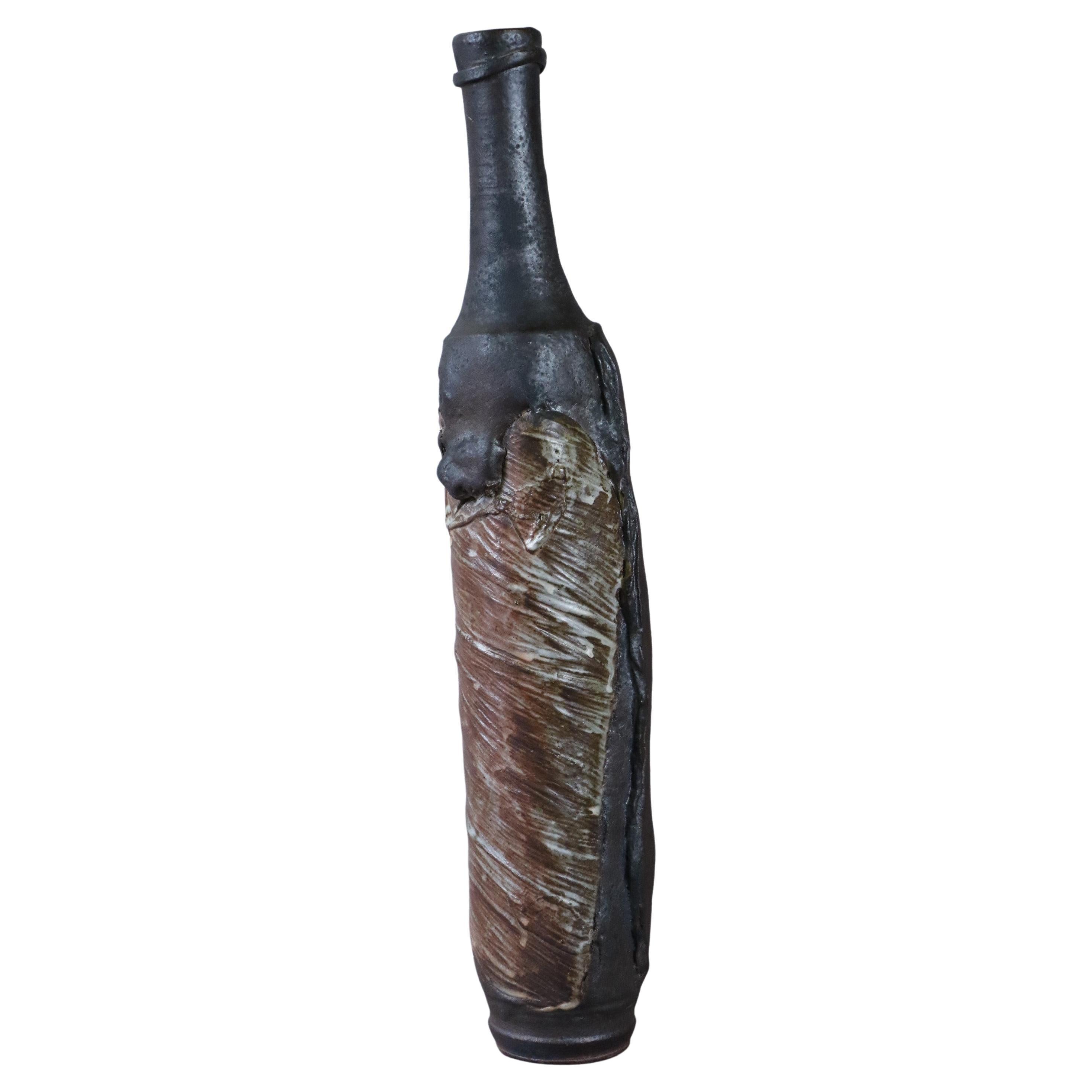 Stoneware Bottle by Alain Gaudebert, Puisaye - Era Joulia Debril Deblander Lerat

The bottle is made of stoneware and is glazed in earthy, shaded tones. It presents a very original work on the material. The inspiration is brutalist.
It is signed