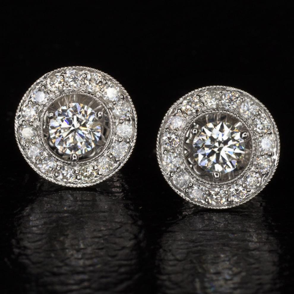 A beautiful pair of sparkling stud earrings with a total weight of 2.30 carats and an even bigger look. 
The halo adds a larger diameter to the diamonds which gives the earrings a much larger appearance and an important sparkle. In the center of