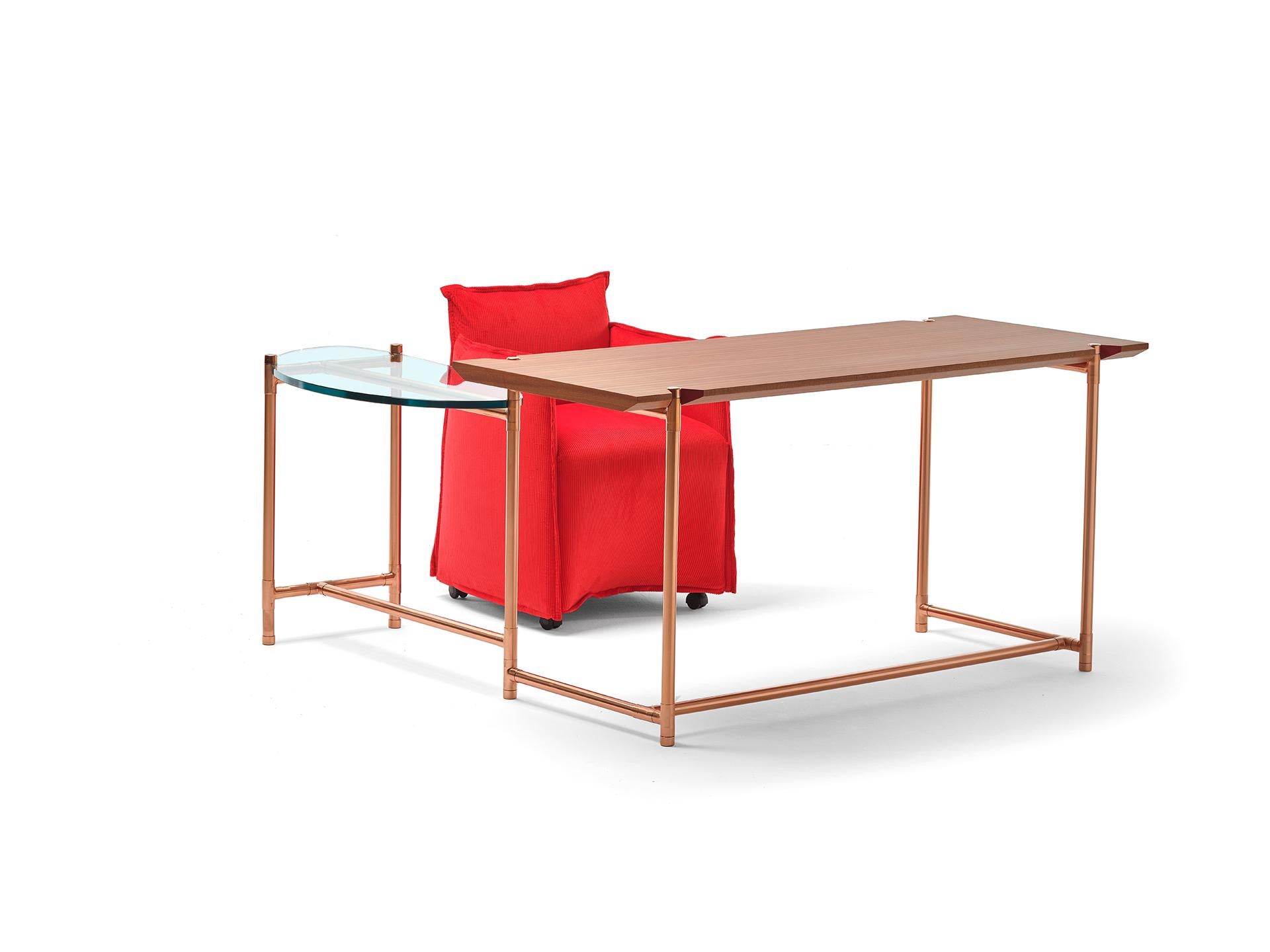 An original desk with a wooden top and a glass extension that can rotate around a central pivoting point, like the hand of a clock. This allows the table to expand and contract its usable surface and to adapt to different uses: a dedicated support