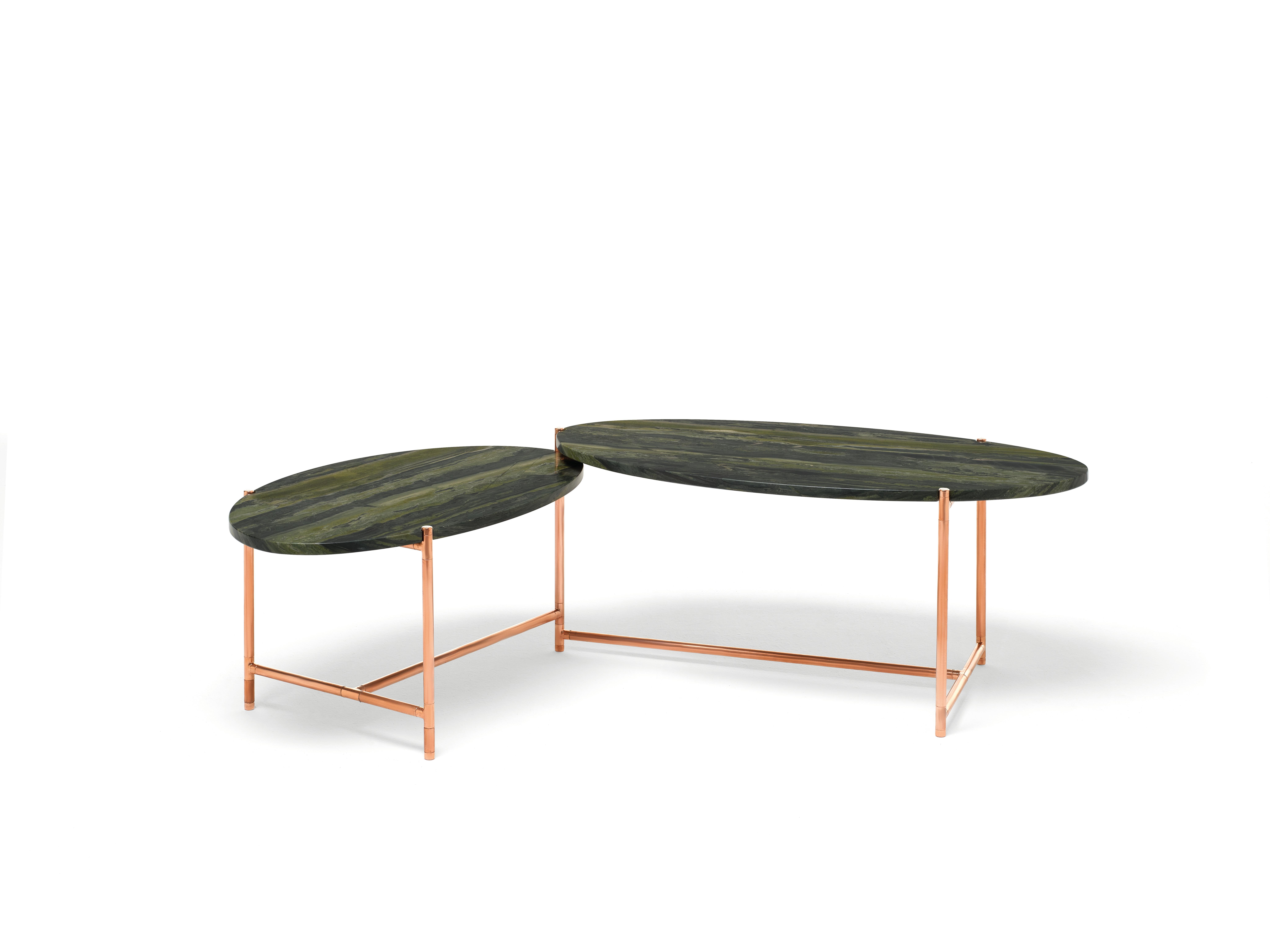 An original coffee table with two tops that can rotate around a central pivoting point, like the hands of a clock. This allows the table to expand and contract its usable surface and to adapt to different uses and spaces. The specular curves of the