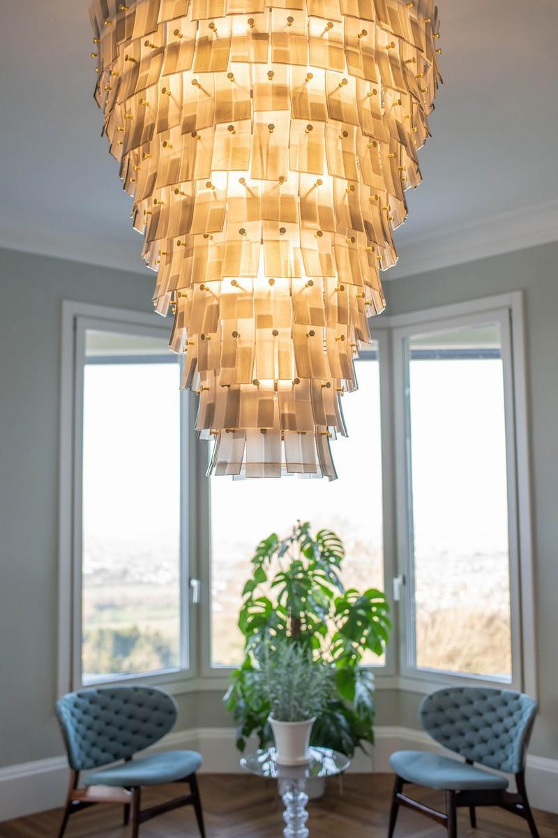 The modern style glass chandelier Chimera is our tribute to the design of the 1960s and its typical creative patterns. This lighting work is composed of modular elements: glass listels in the tones of amber, handcrafted using a combination of