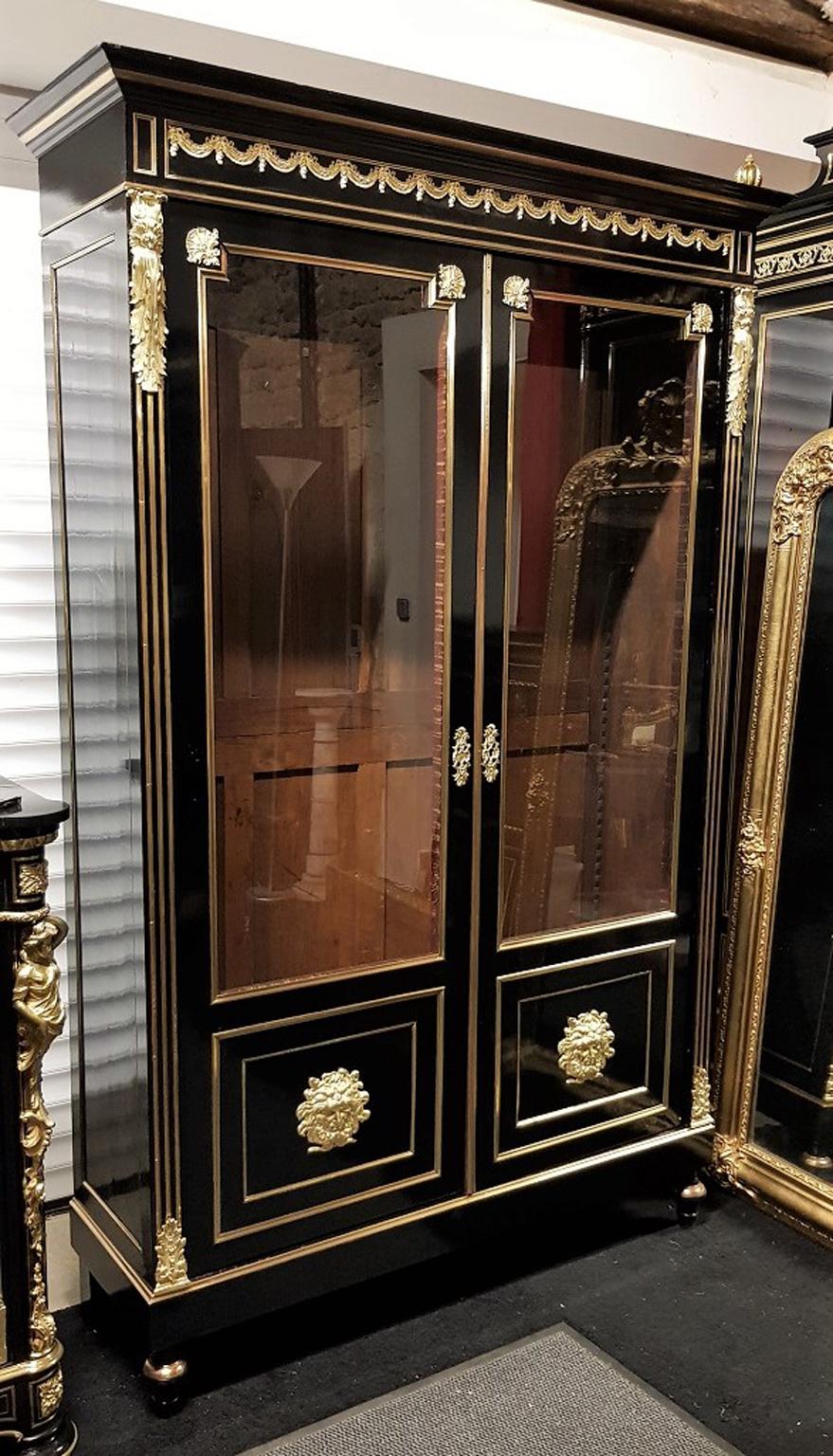 Imposing big size vitrine bookcase with 2 glasses doors, in blackened fruitwood with a rich gilt bronze ornamentation and Hercules mask on the doors. 
Napoleon III, France, 1870.

Excellent condition, enterily restored by our specialists.
  