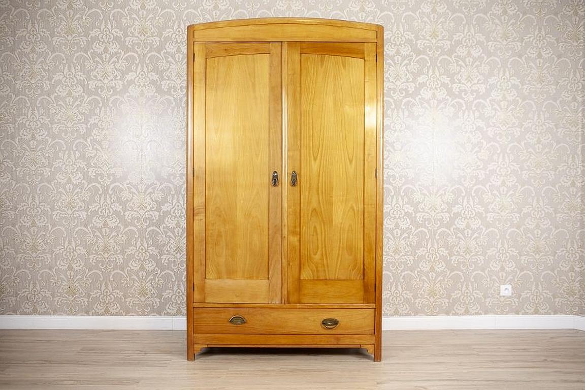 Big Wardrobe from the Interwar Period Veneered with Ash

We present you a double-leaf piece of furniture, closed with a fully functional latch bolt lock.
The inside is intended for hanging clothes on a metal rod.
There is a big drawer in the lower