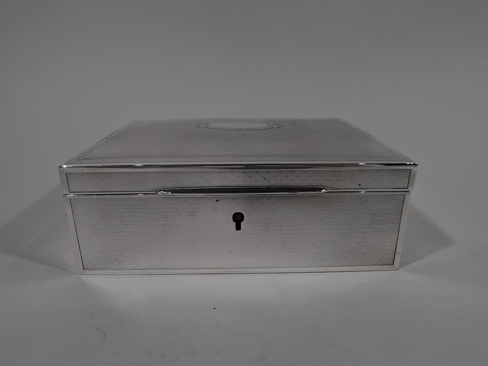 American Art Deco sterling silver jewelry box, circa 1920. Rectangular with straight sides. Cover hinged, tabbed, and gently curved. Engine turned wave ornament in plain frames. Cover top has ornamental oval frame (vacant). Fully marked with maker’s