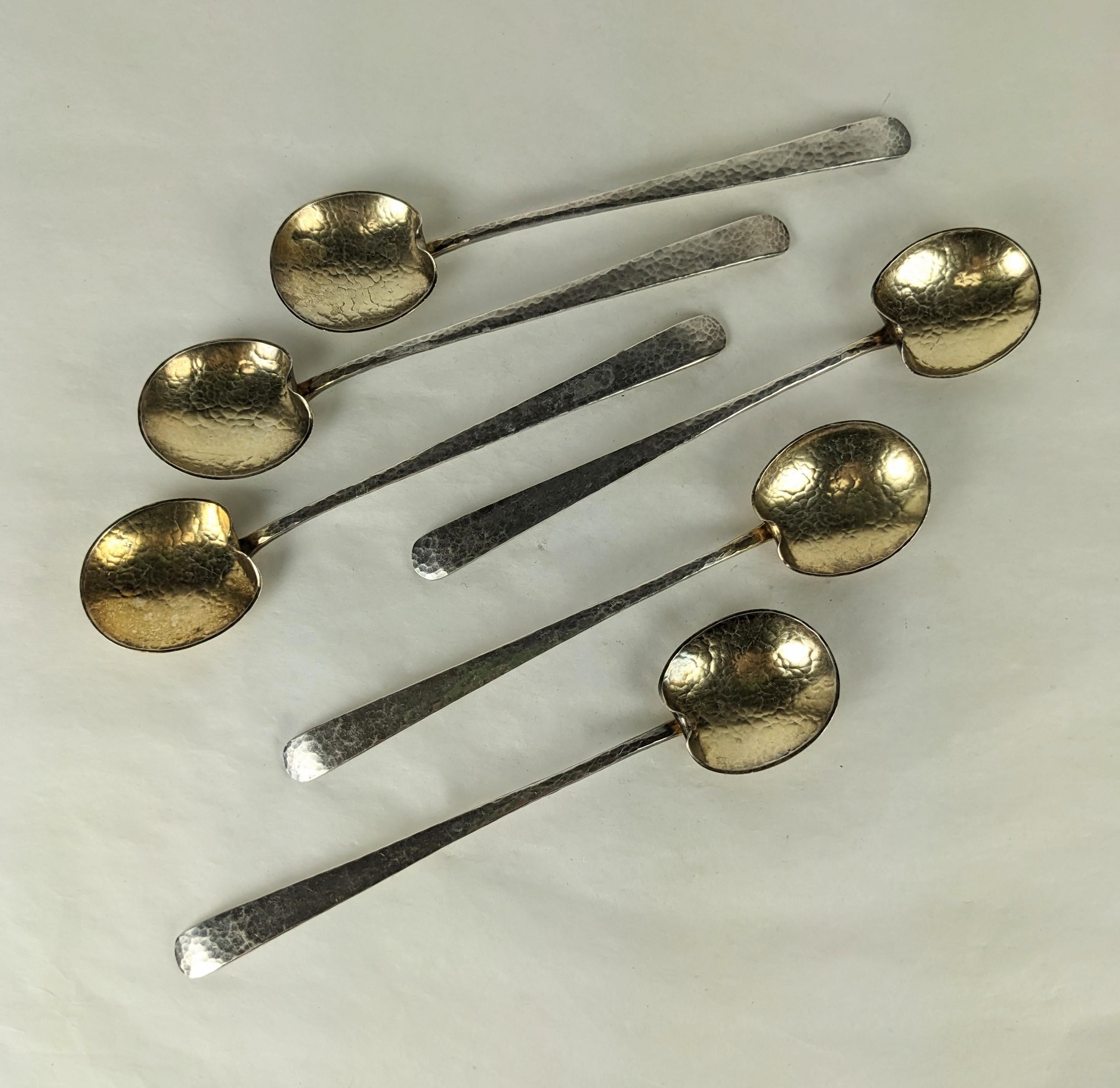 Joli et inhabituel ensemble de cuillères Arts et Métiers en sterling avec des bols en vermeil, martelées à la main, datant du début des années 1900. Magnifique bol en forme de lys. 
5.5