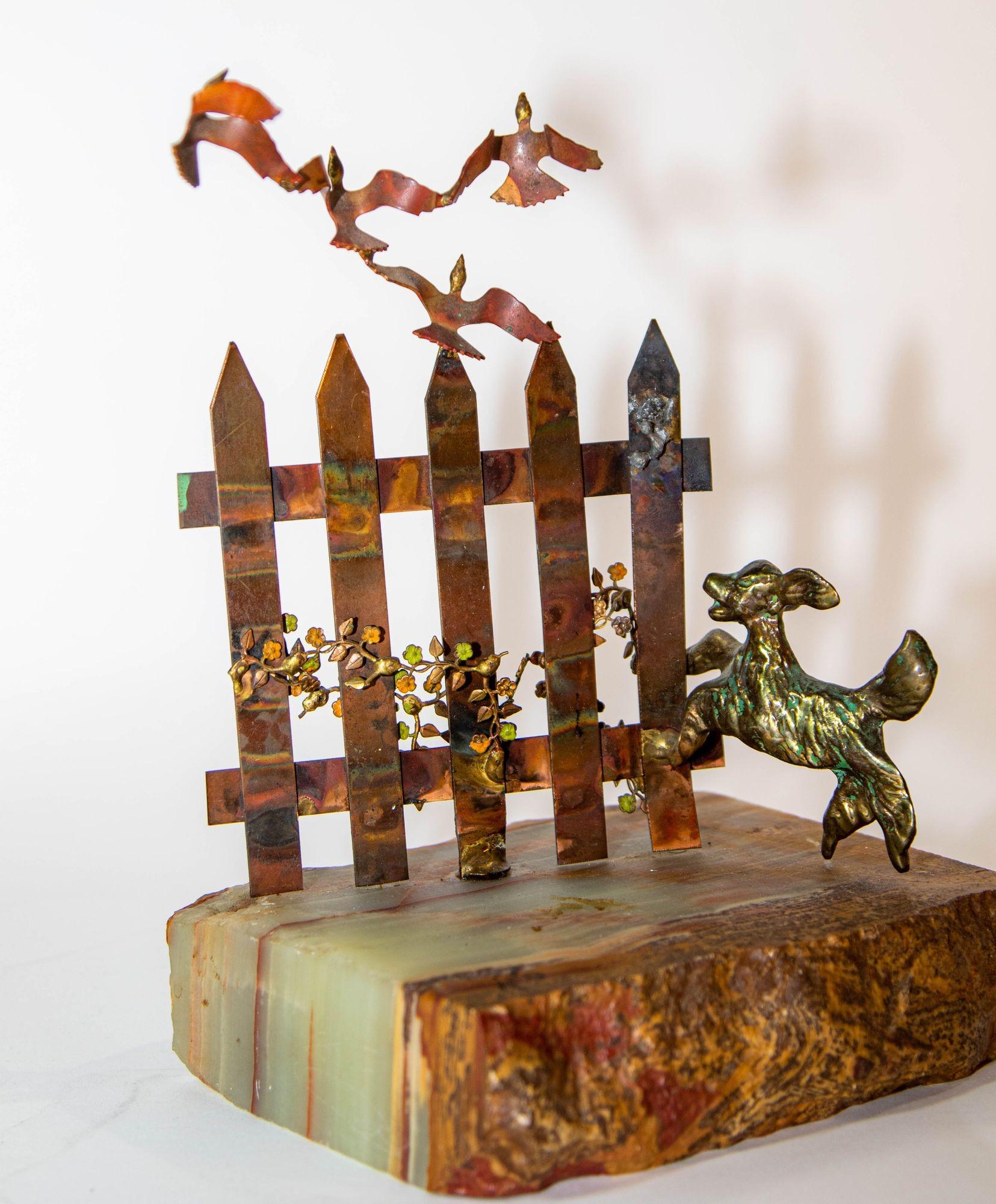 Scultura in metallo vintage BIJAN Cane con inseguimento di uccelli Rame e ottone su base di pietra.
Scultura in metallo di Bijan del Mid Century Modern, 1960 circa, anni '70.
Questa scultura brutalista in metallo di Bijan presenta un cane in bronzo