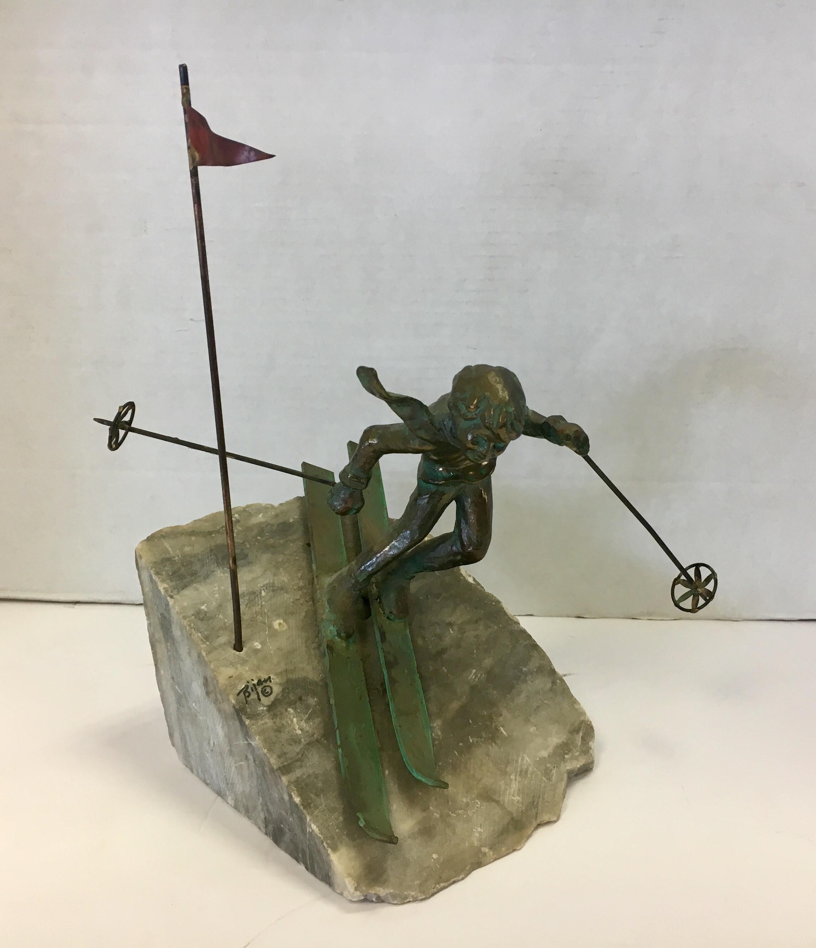 Brutalist signed brass Bijan table sculpture depicting a downhill ski racer maneuvering through a flagged gate. The sculpture sits on a heavy marble/stone base and is exceptional.
