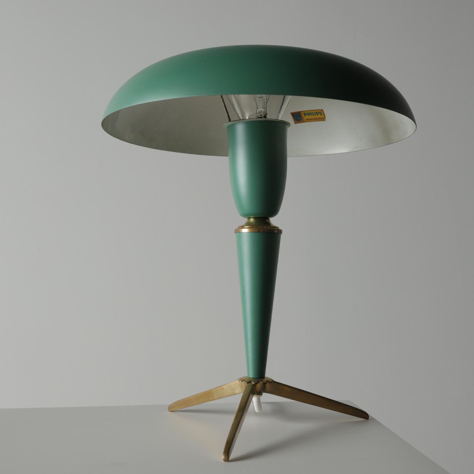 Materials: Gold painted tripod base made of brass. Some brass parts. Dark green painted conical plastic stem and socket holder. Dark green metallic painted aluminium mushroom lampshade with a centre hole. Painted white on the inside.

Period:
