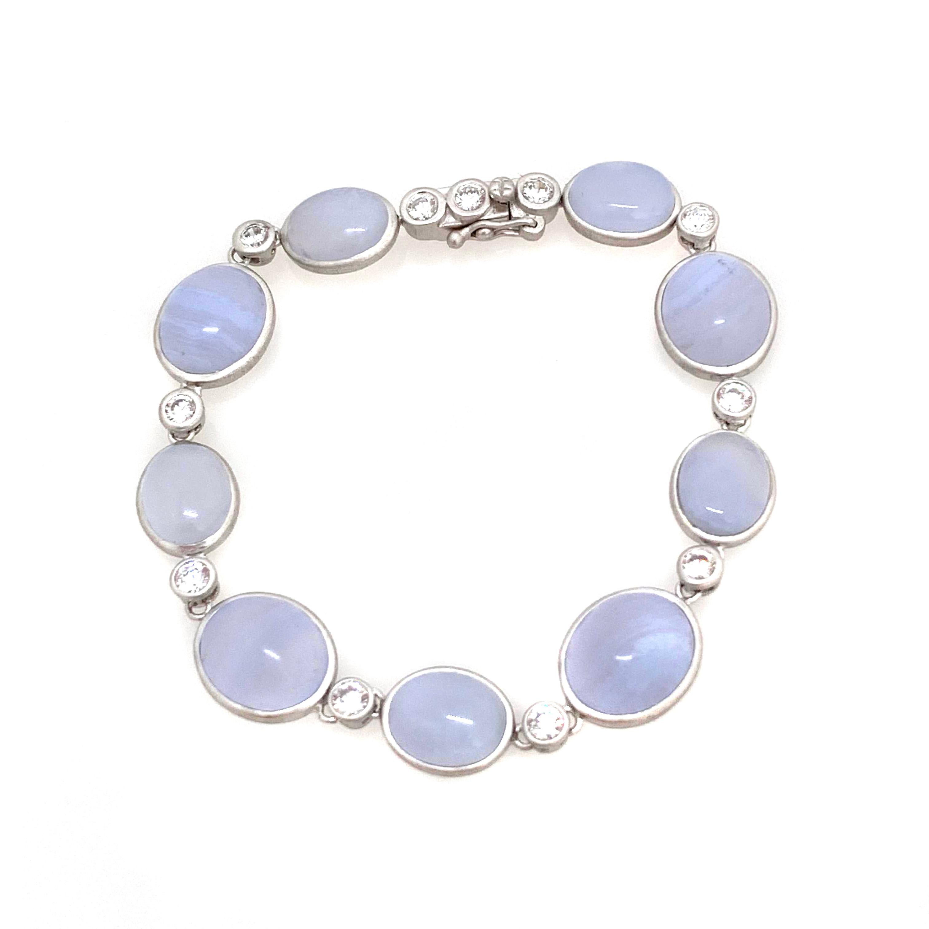 Discover Bijoux Num bezel-set oval chalcedony station bracelet.

This beautiful bracelet features 9 pieces of beautiful periwinkle purple-ish blue cabochon-cut oval chalcedony, handcrafted brushed satin texturing technique, and hand set in platinum