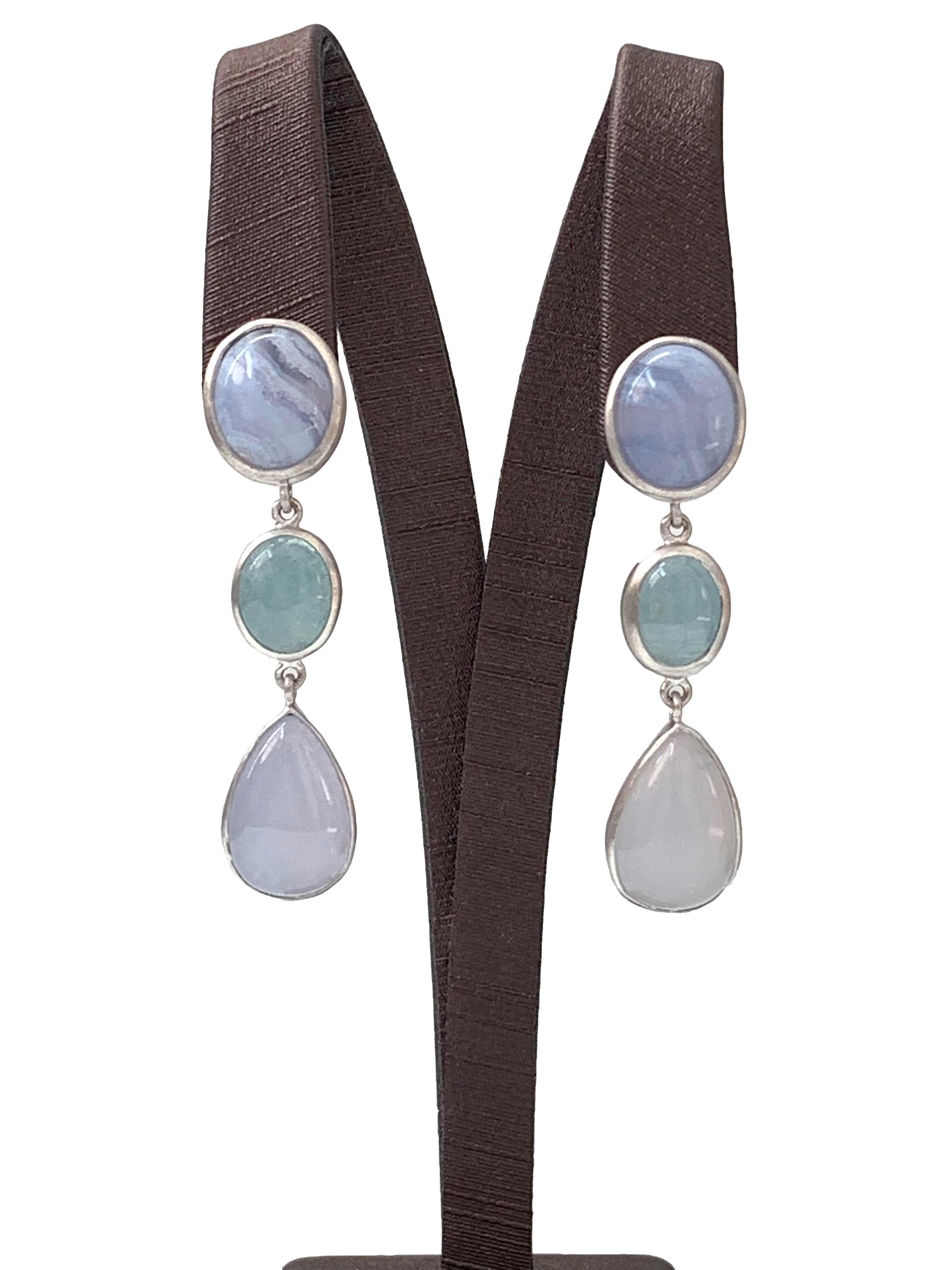 Discover these oval chalcedony, oval aquamarine and pear-shape chalcedony Dangle Earrings.  

The earrings feature 6 pcs of beautiful cabochon-cut chalcedony and aquamarine with unique periwinkle purple-ish and pastel blue hue, handcrafted brushed