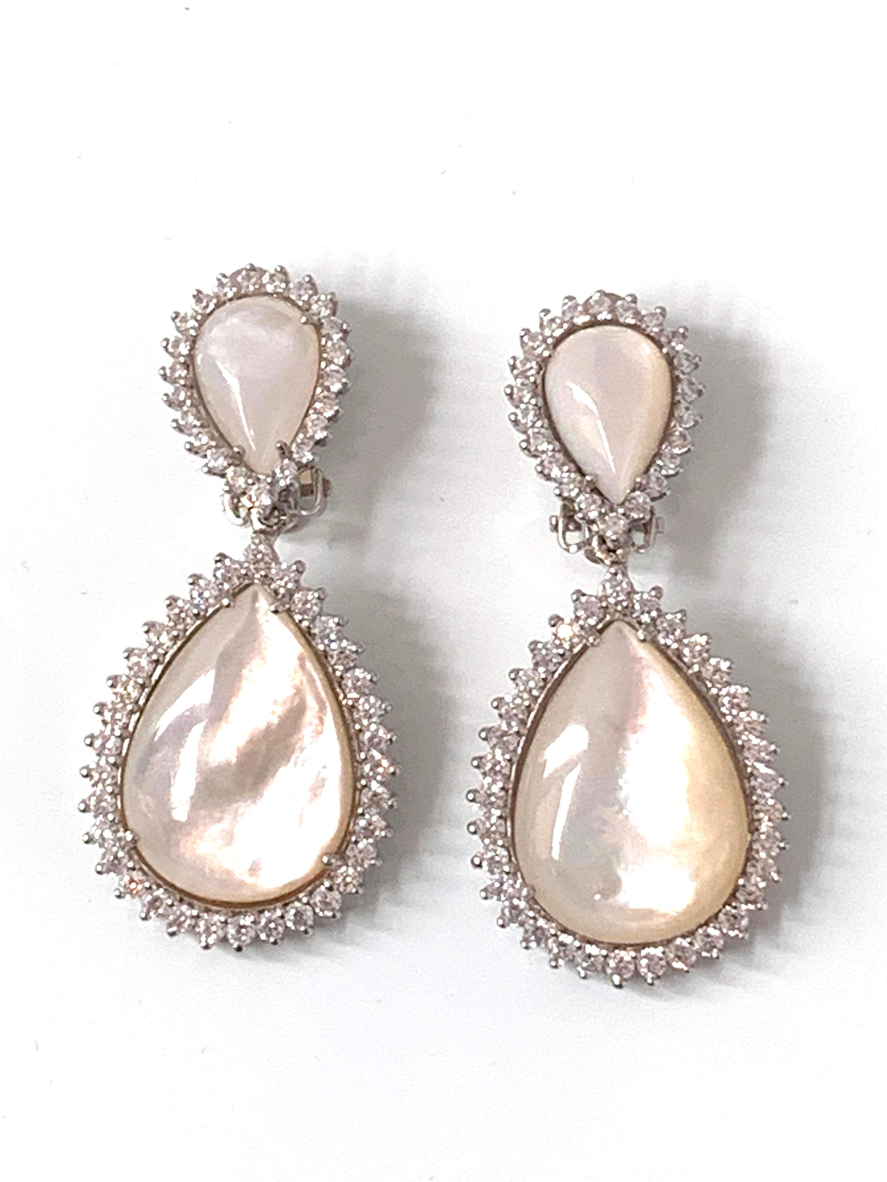 Double pear shape mother of pearl Drop Earrings surrounded with faux diamond CZ. These earrings feature 4 beautiful iridescent cabochon-cut pear shape mother of pearls and over 100pc of round cubic zirconia, handset in platinum rhodium plated