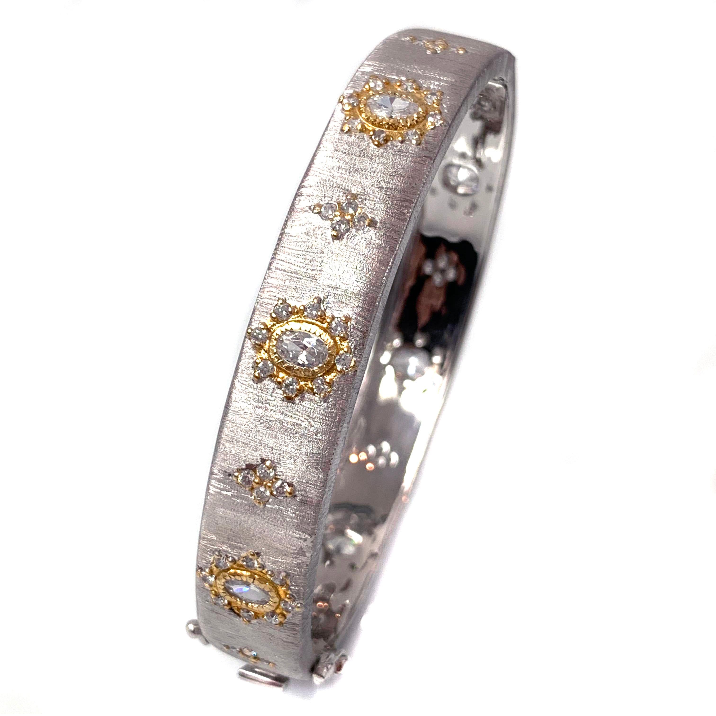 Bijoux Num hand-engraved star pattern two-tone sterling silver bangle bracelet. 

This beautiful bracelet features over 80 pcs of oval and round simulated diamonds, handset in two-tone platinum rhodium and 18k yellow gold plated sterling silver,