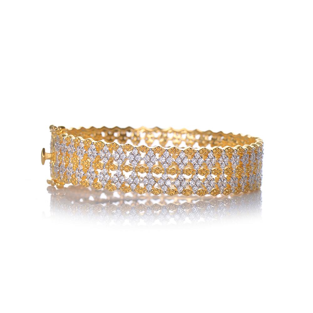 Beautiful bracelet featuring two rows of diamond shaped encrusted cubic zirconia with gold edged pattern. Push clasp closure with double '8' safety locks. 18k Gold and Platinum Rhodium two tone plating over sterling silver. Marked: NUM