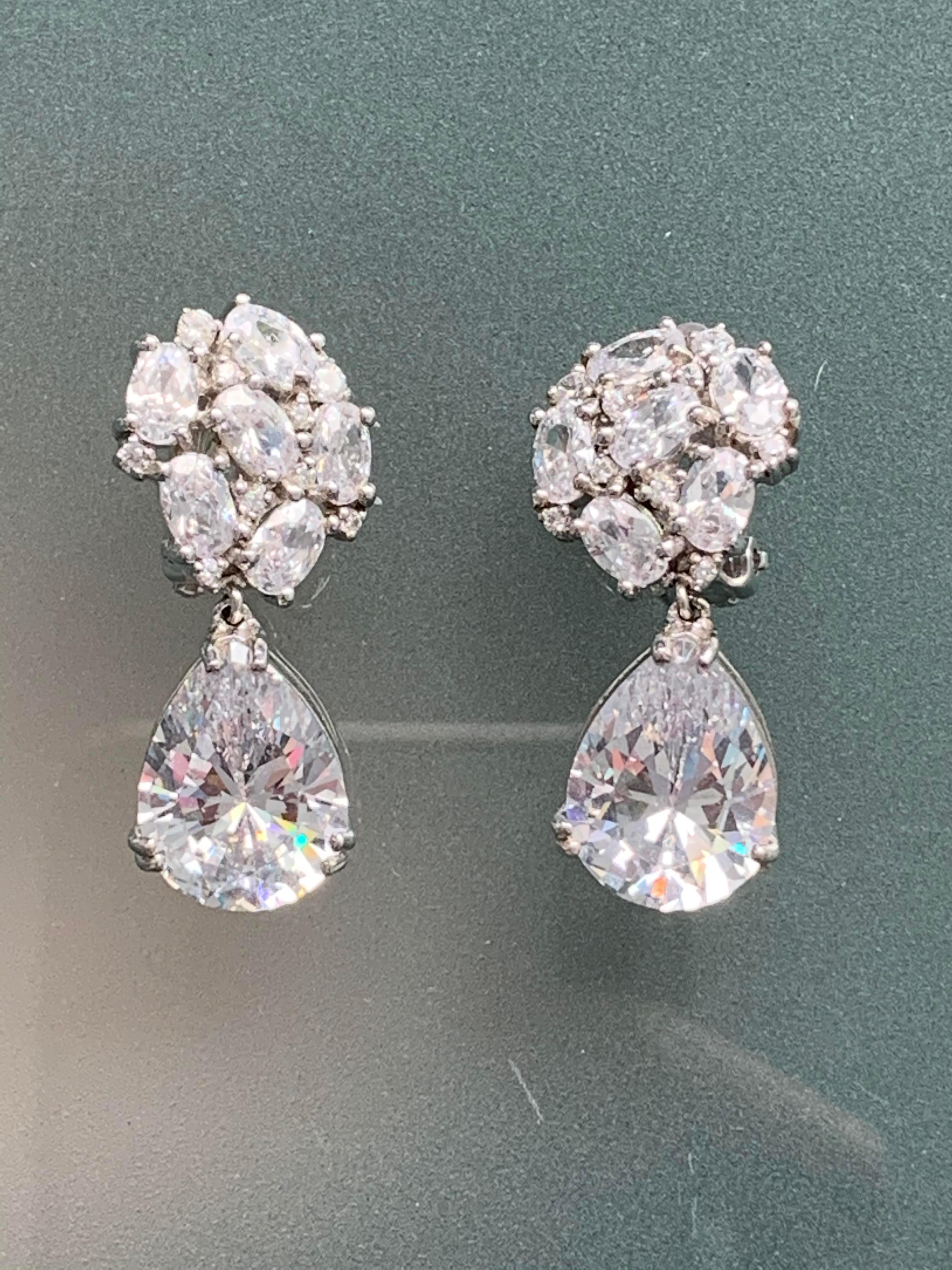 Stunning Runway Faux Diamond Drop Earrings, crafted in platinum plated sterling silver and encrusted with sparkling CZ. The pear shape drops are each equal to 6ct in size top quality Cubic Zirconia. The earrings give a lot of bling. Top Round