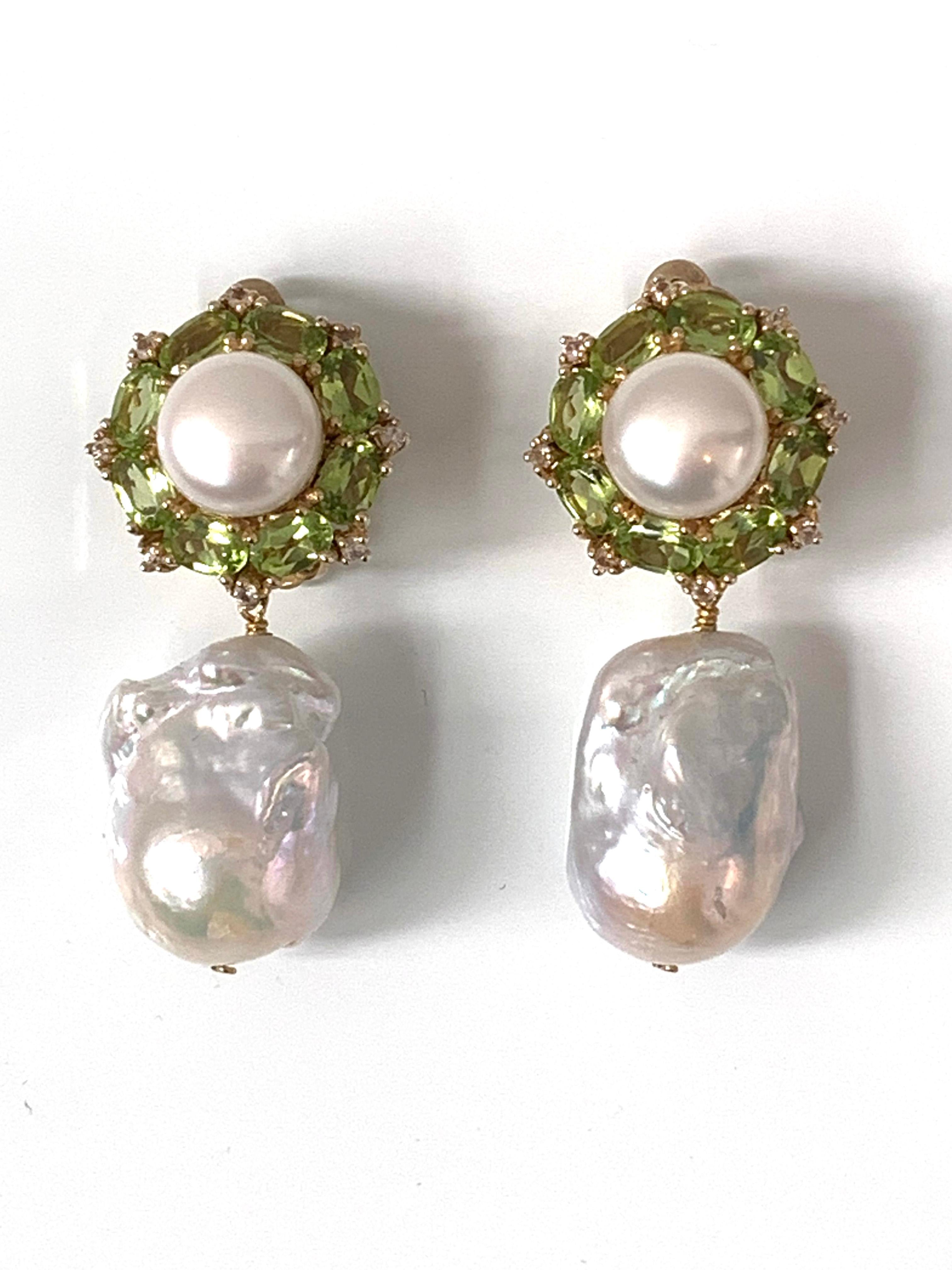 These earrings feature a large pair of high luster white baroque pearls (17mm). Both are elongated baroque shapes, blemish free and possess brilliant luster. Top part of the earrings feature a pair of high luster fresh water pearls, oval peridot,