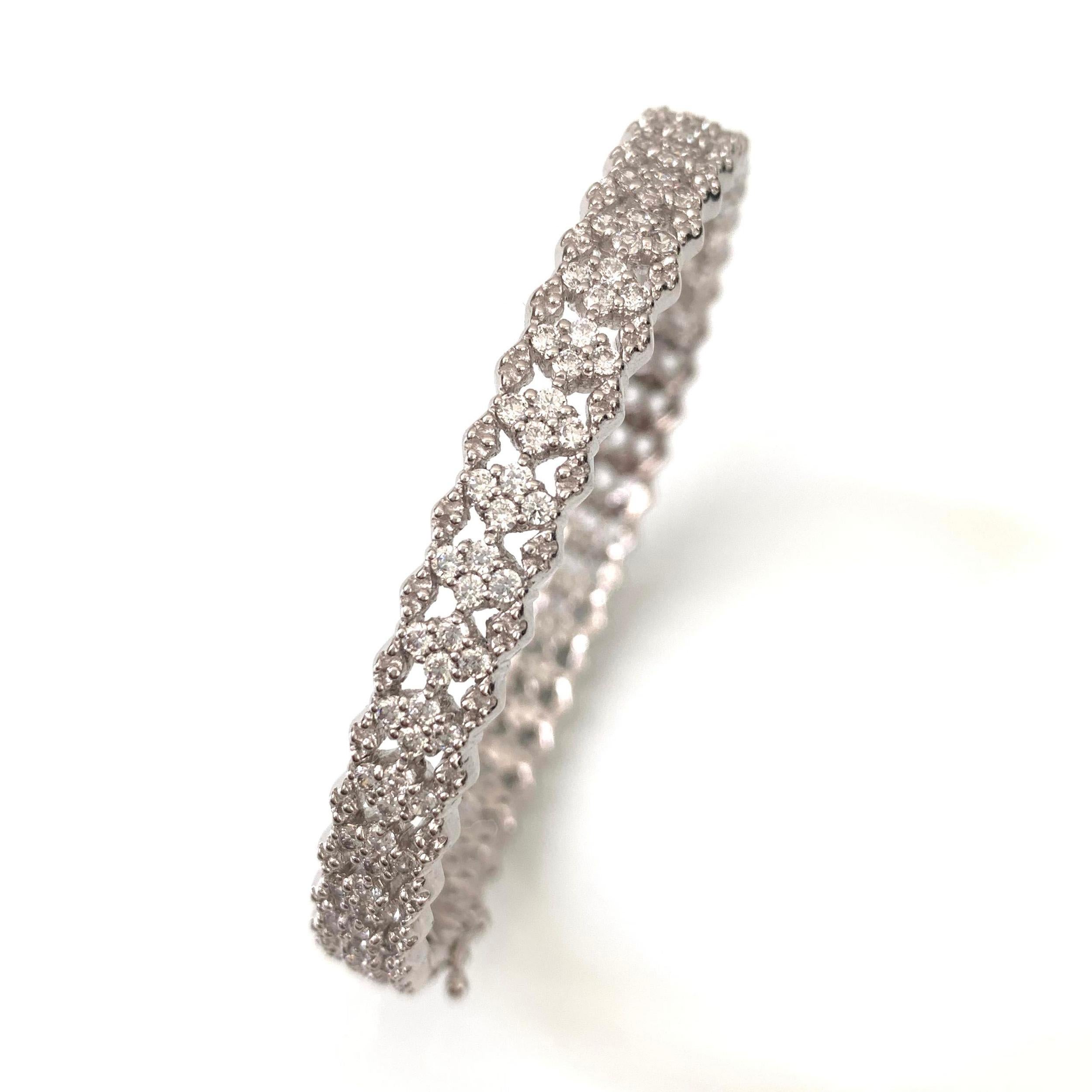 Beautiful skinny bracelet featuring a row of diamond shaped encrusted cubic zirconia with silver edged pattern. Push clasp closure with double '8' safety locks. Platinum Rhodium plating over sterling silver. Marked: NUM 925.

Bracelet is 0.25