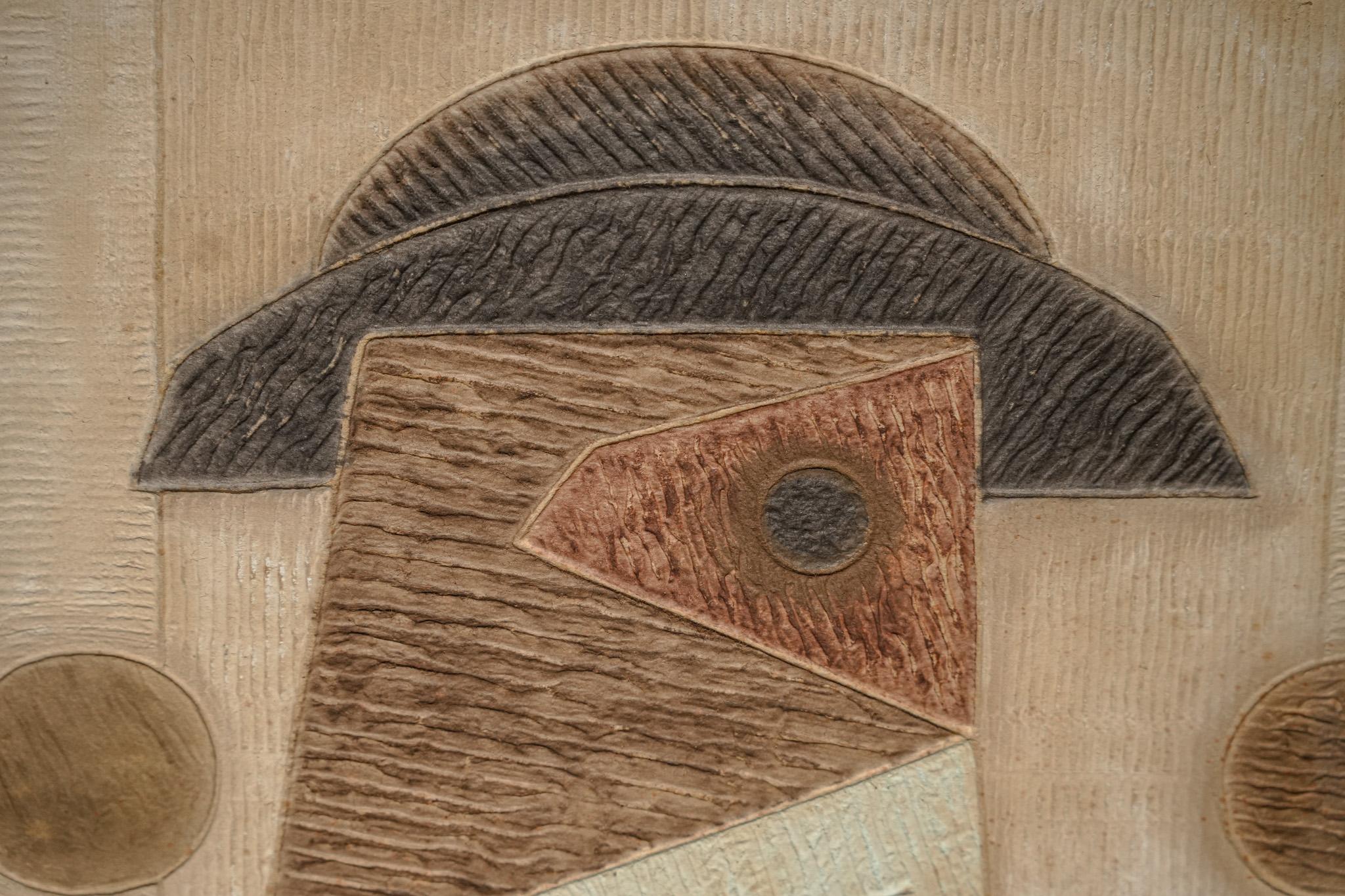 City Dweller is a mixed-media print created by Bik Chuen Ha in 1994. Using geometric and abstract forms, Ha portrays a modern figure wearing a hat, composed of triangles, circles, and irregular shapes. Layered textures and carved lines give the
