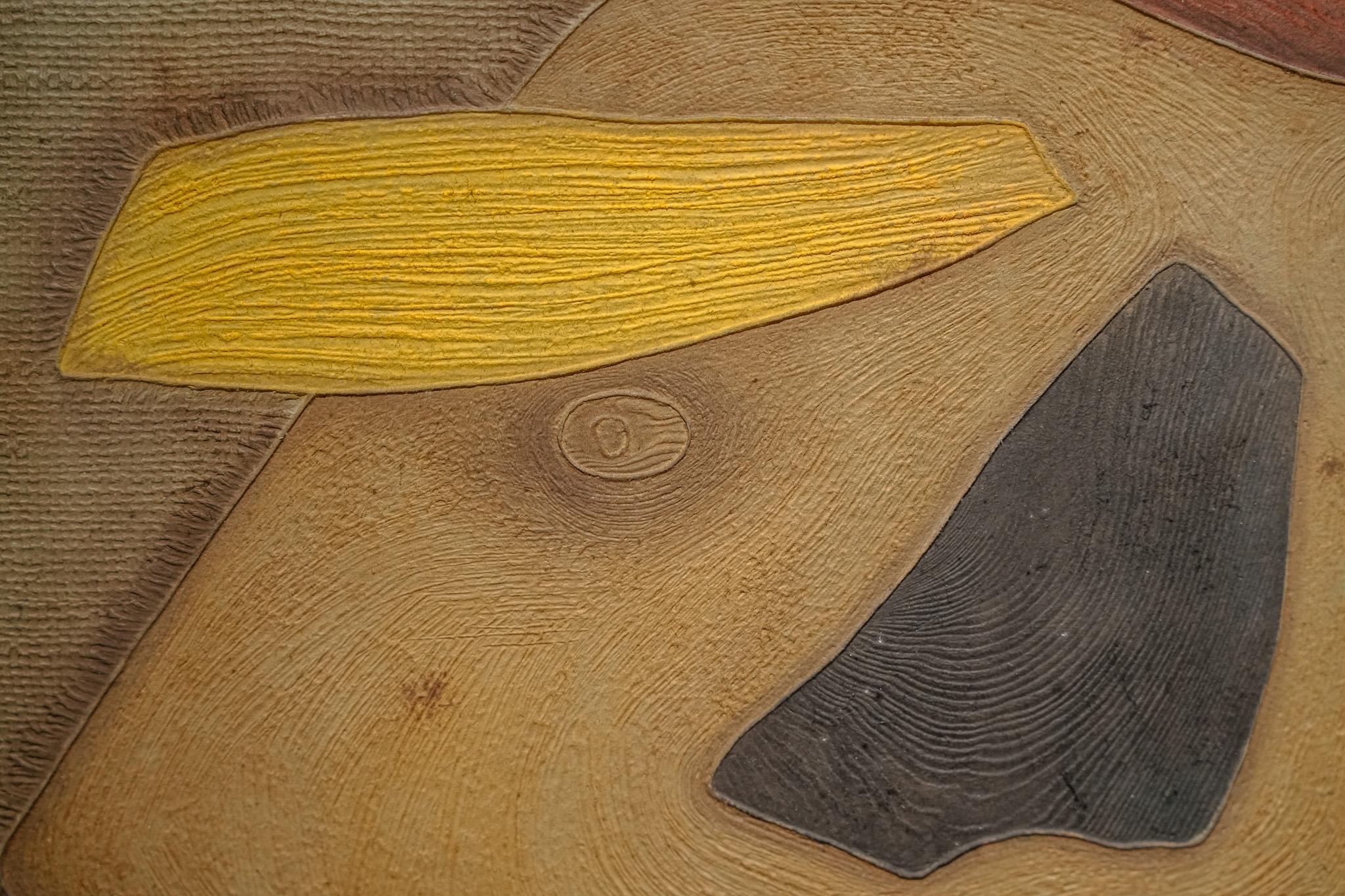 Great Wisdom Appears Simple is a mixed-media print created by Bik Chuen Ha in 1994. The composition is built from abstract forms and vivid colors, with a central mass resembling a solid stone marked by layered carvings that evoke the passage of