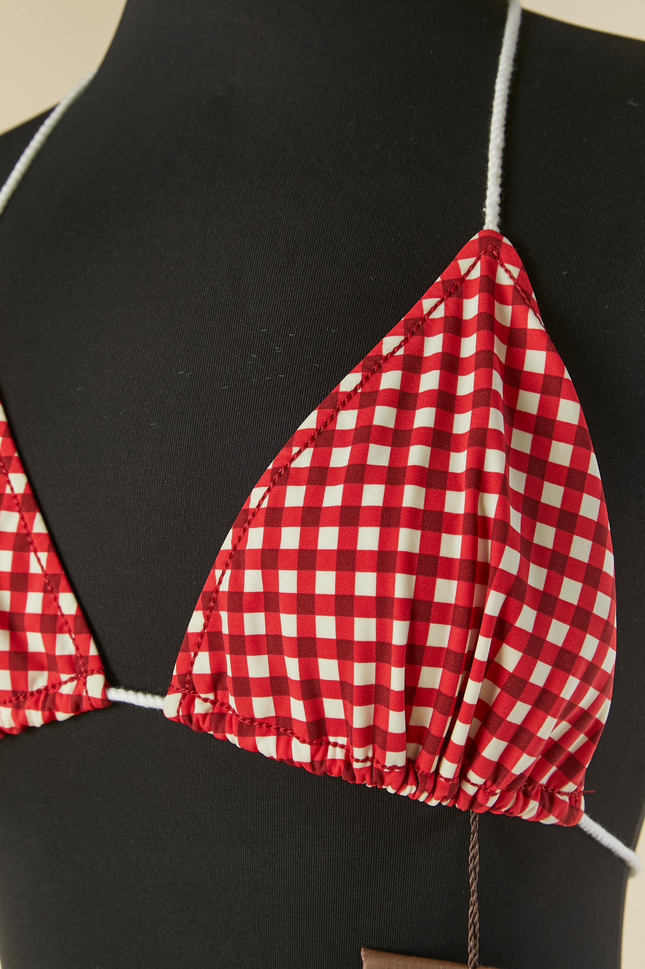 Bikini with red and white check pattern. Main fabric composition: 62% nylon, 38% elastane. Lining composition: 72% nylon, 28% elastane. 
White cotton rope on the bra and on the panty. 
Brown nylon pocket provided. 
SIZE 38 / M 