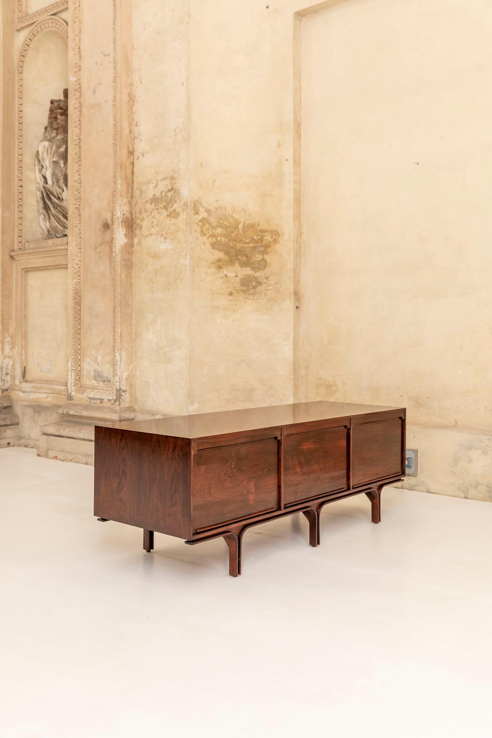 Buffet iconique conçu par Gianfranco Frattini pour Bernini. Italie 1960 ca. 
Trois portes tambour verticales sur un côté, avec trois grands et deux petits tiroirs sur la gauche, deux petits tiroirs dans chacune des deux autres sections. De l'autre