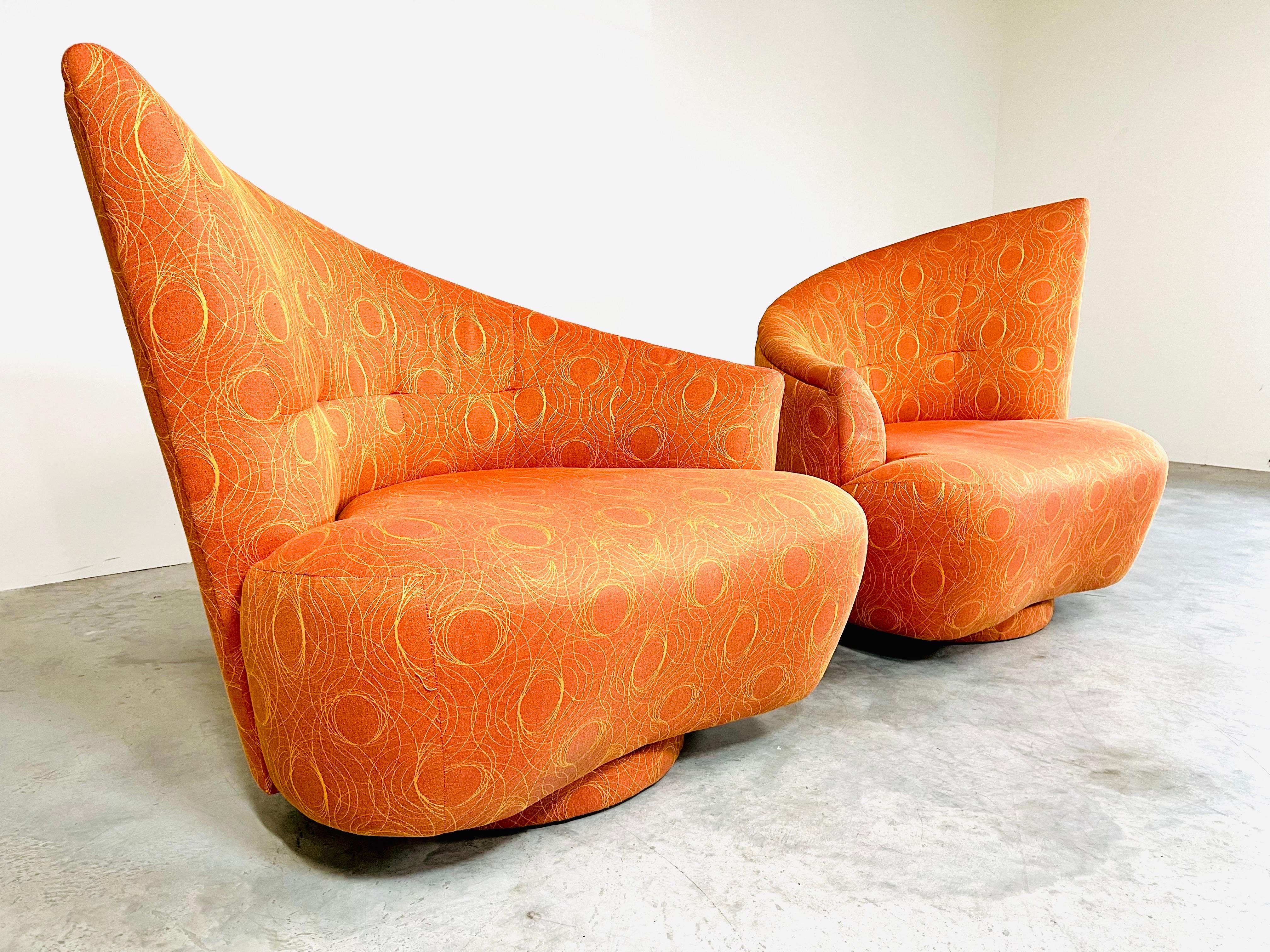 A pair of “Bilbao” swivel lounge or club chairs designed by Vladimir Kagan for Weiman, circa 1980 having original circular patterned fabric that has been well maintained and barely used. A beautiful design that blends comfortable function with
