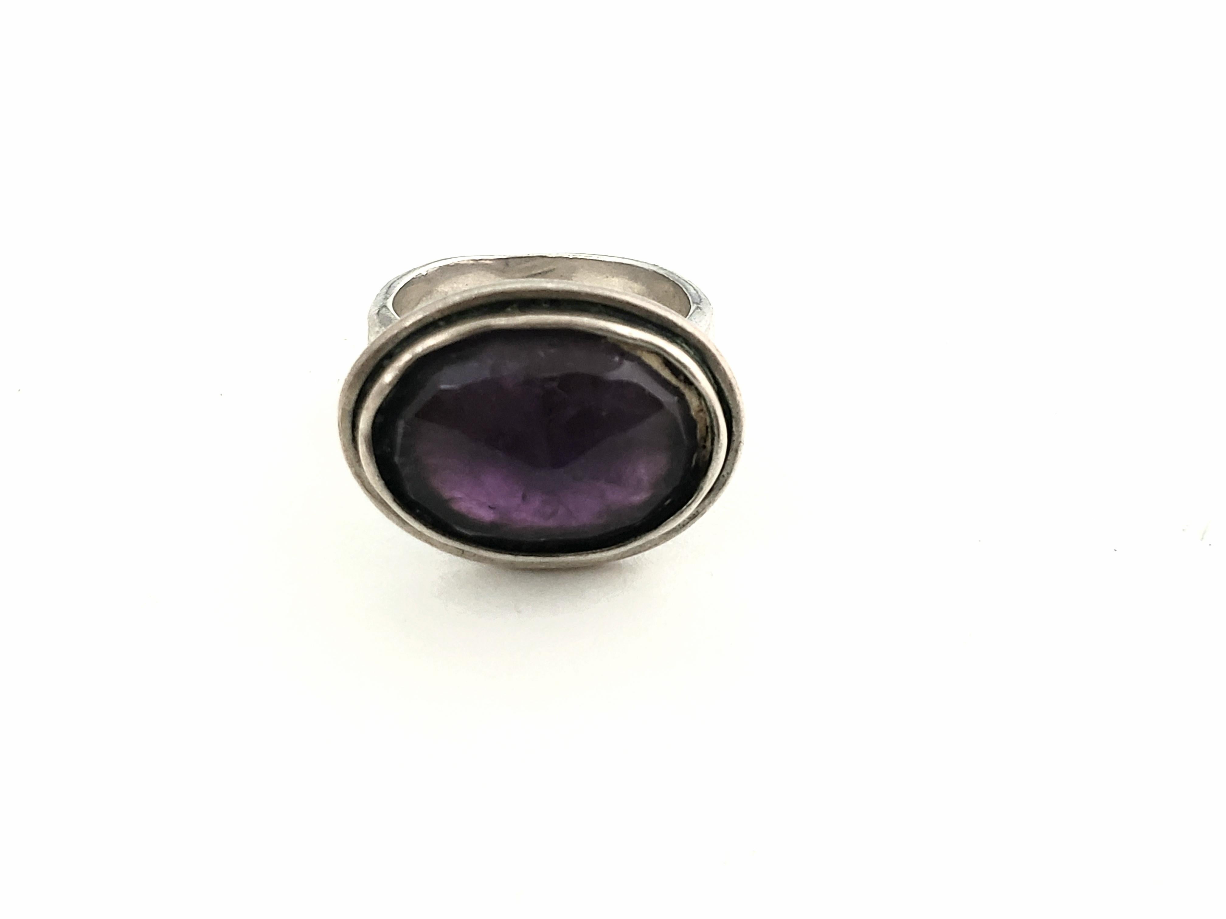 Bili Sterling Silver Checkerboard Faceted Amethyst Ring 

Large checkerboard faceted amethyst set in a bezel setting in an east/west direction.  The purple color is a wonderful deep purple, but not too dark; very pretty stone. Band is quite thick