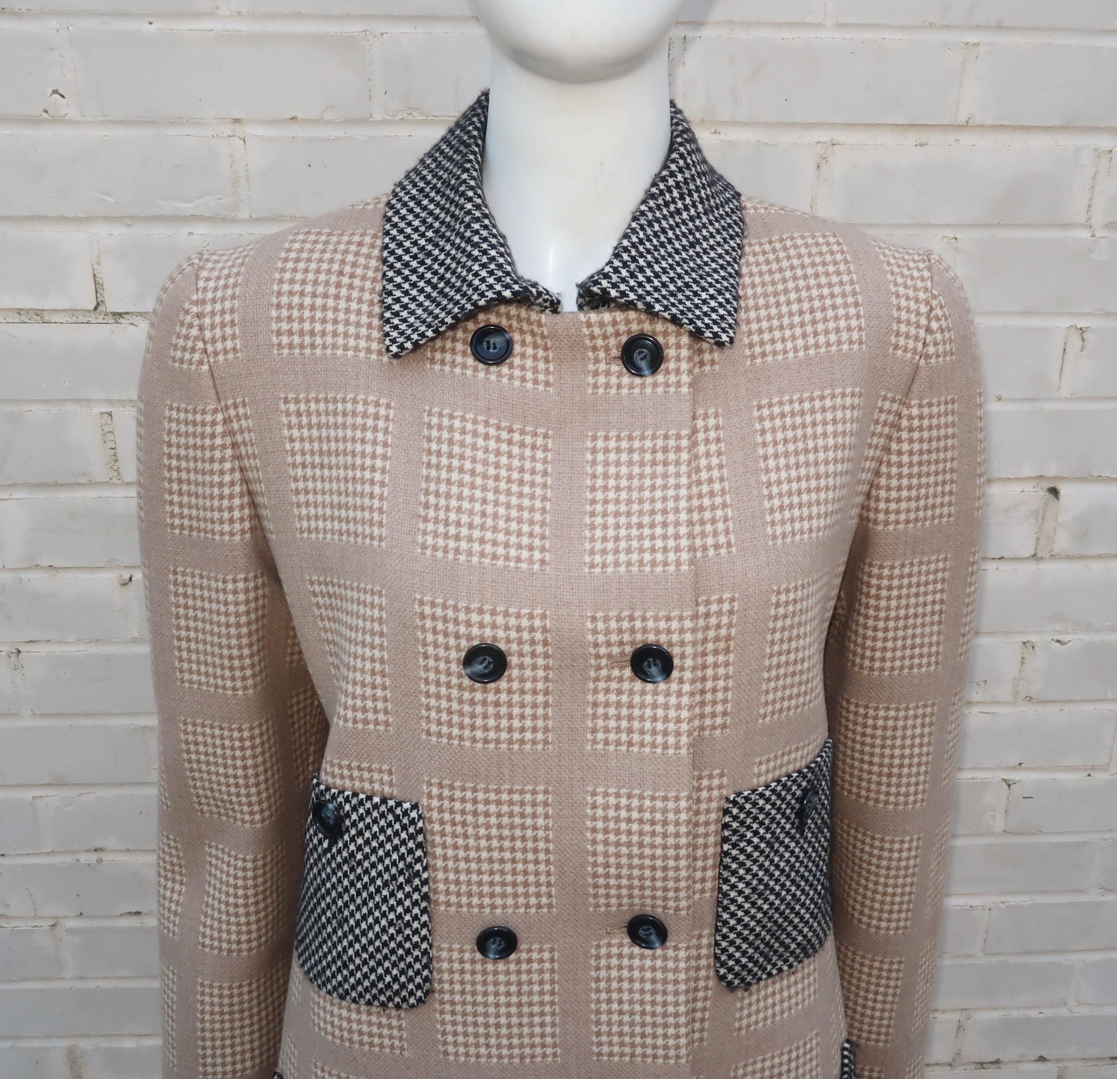 This Bill Blass 1980’s cashmere blend wool jacket mixes two houndstooth fabrics combining a pale camel and creme check with a black and creme check at the collar and pockets.  The unique double breasted construction and double row of buttoned