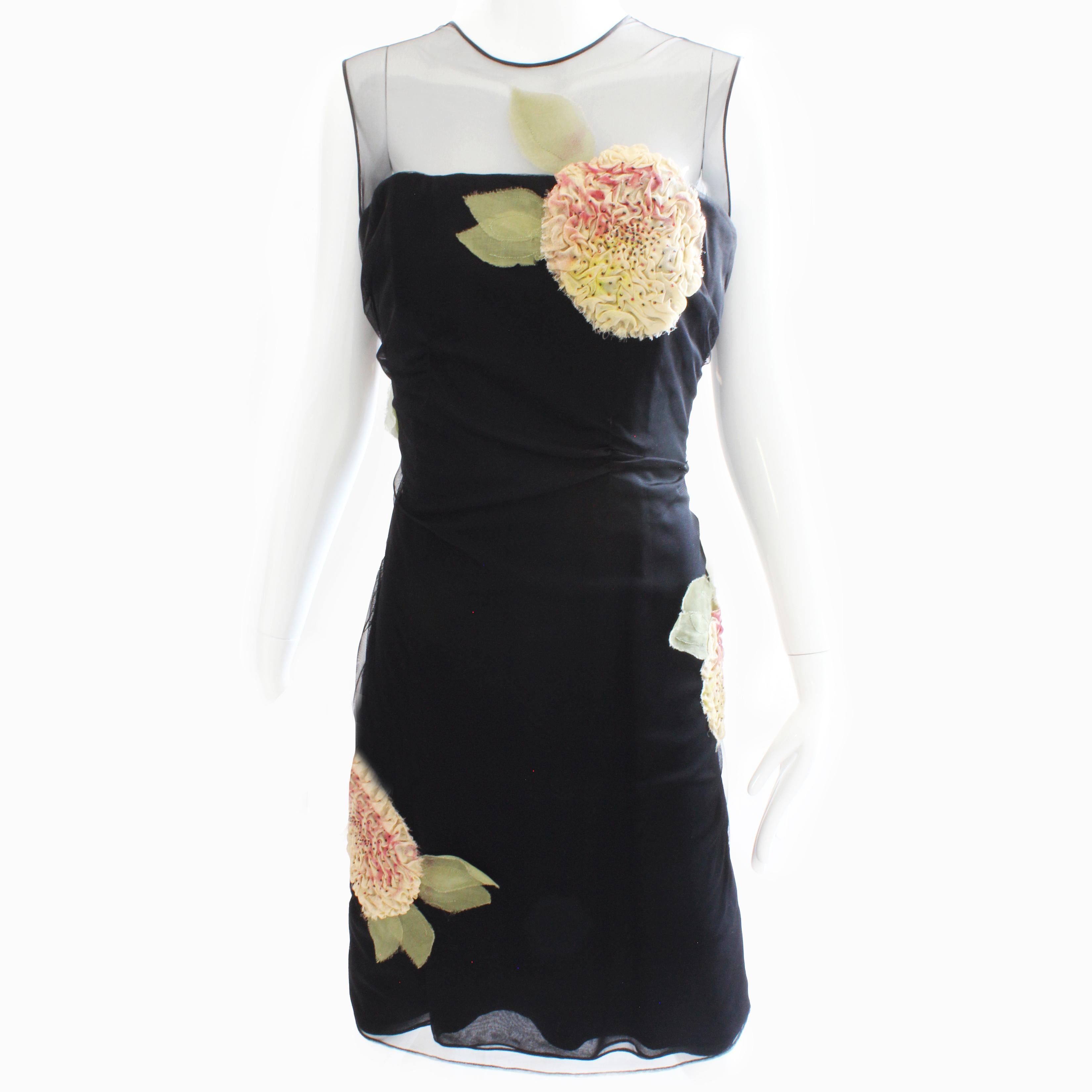 Authentic, preowned and vintage Bill Blass Black Cocktail Dress with sculptural floral appliqué, likely made in the late 70s. 

A chic little black dress with a twist! It features an inner corset made from black silk satin, which gives it great