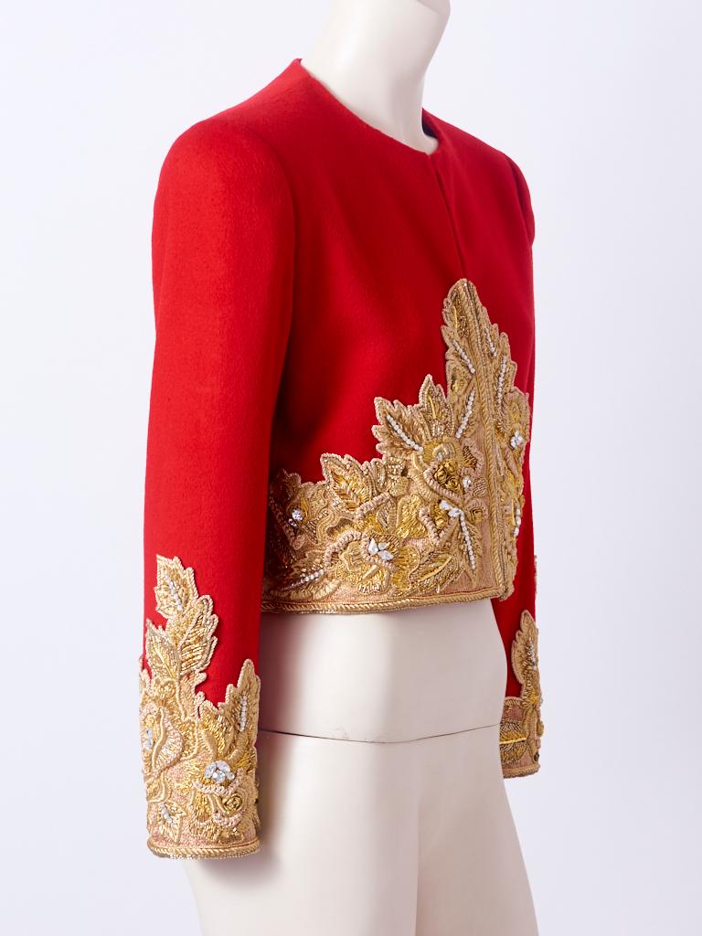 Bill Blass, red wool, collarless, bolero jacket, heavily, embroidered with gold lame, having bead work and strass detail on the sleeves and body of the jacket.  Hidden hook and eye front closures. C. 1980's.