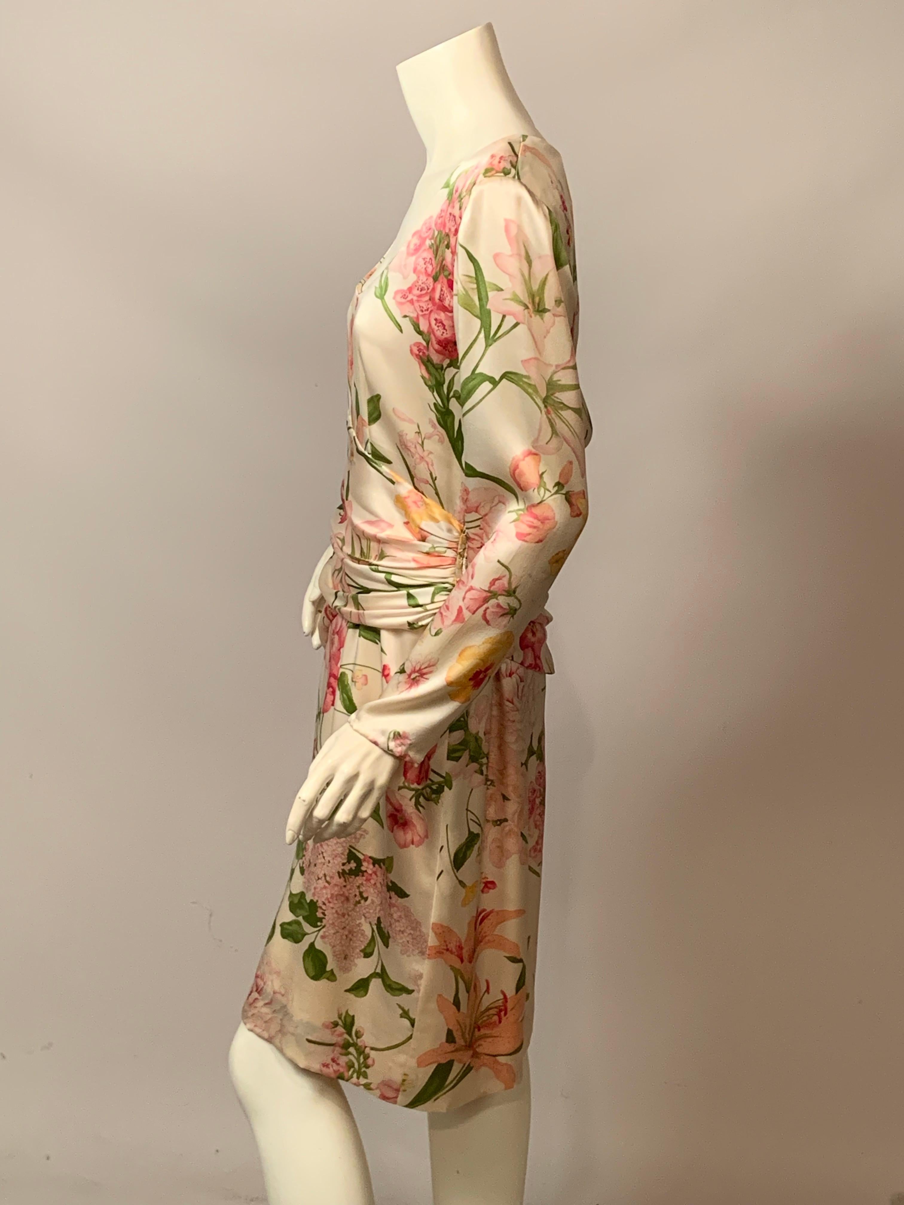 Bill Blass entwarf dieses prächtige Seidenkleid in den 1980er Jahren aus einer wunderschönen floralen Seide in Rosa-, Rosa-, Grün- und Gelbtönen auf cremeweißem Grund. Das Kleid hat einen tiefen Ausschnitt, lange Ärmel mit Stoffknöpfen und