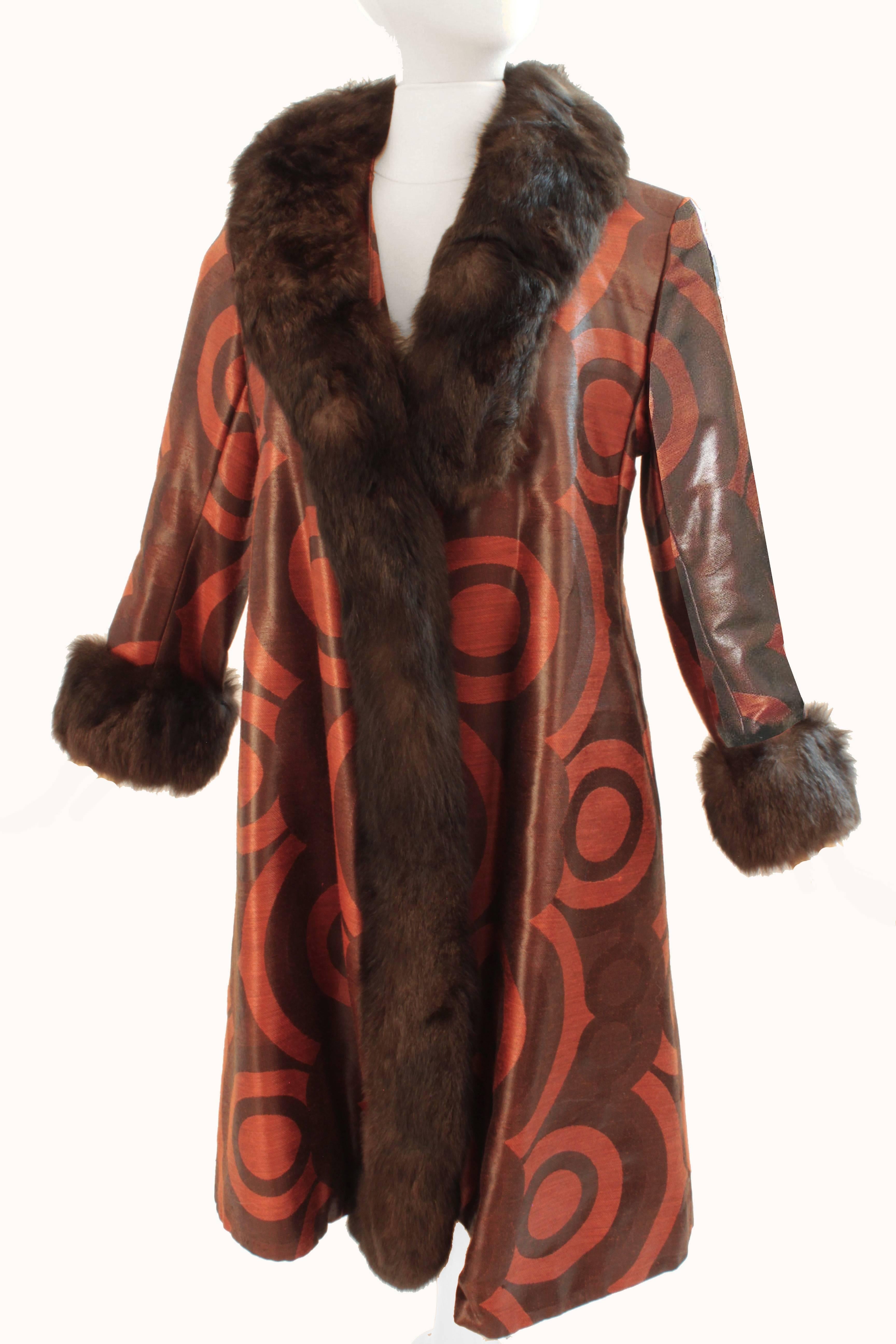This fabulous coat was made by Bill Blass for Bond Street in the 1960s.  Made from what we believe is a coated silk weave (no content tag), it features a brilliant orange red bulls-eye motif against a deep brown background, and is trimmed in dark