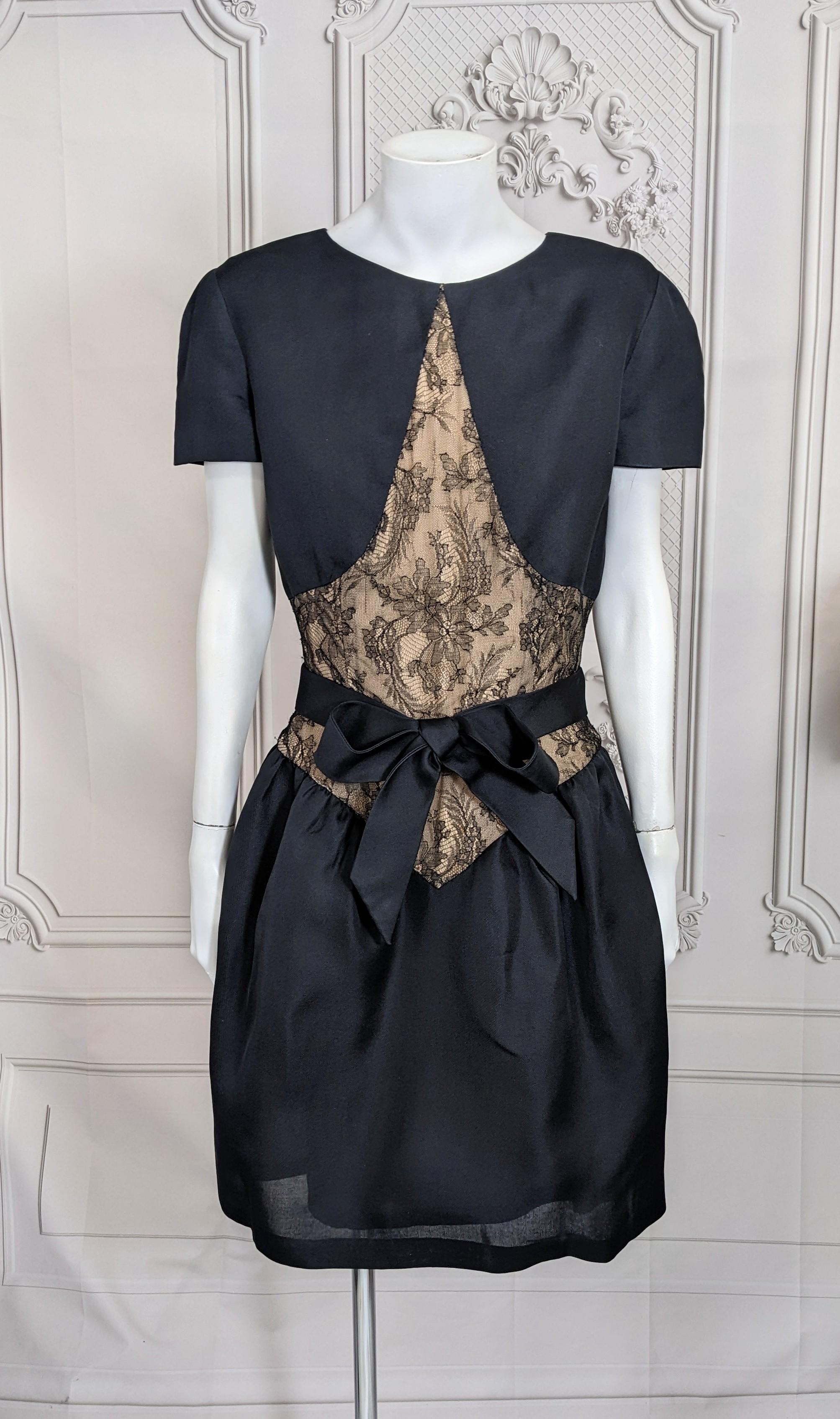 Elegant Bill Blass Organza and Lace Cocktail Dress. Black silk organza with lace inserts with self  belt. Faux bolero design with puffed short skirt. Back zip entry with gazar attached bow belt.
2000's USA. Small size 2-4.