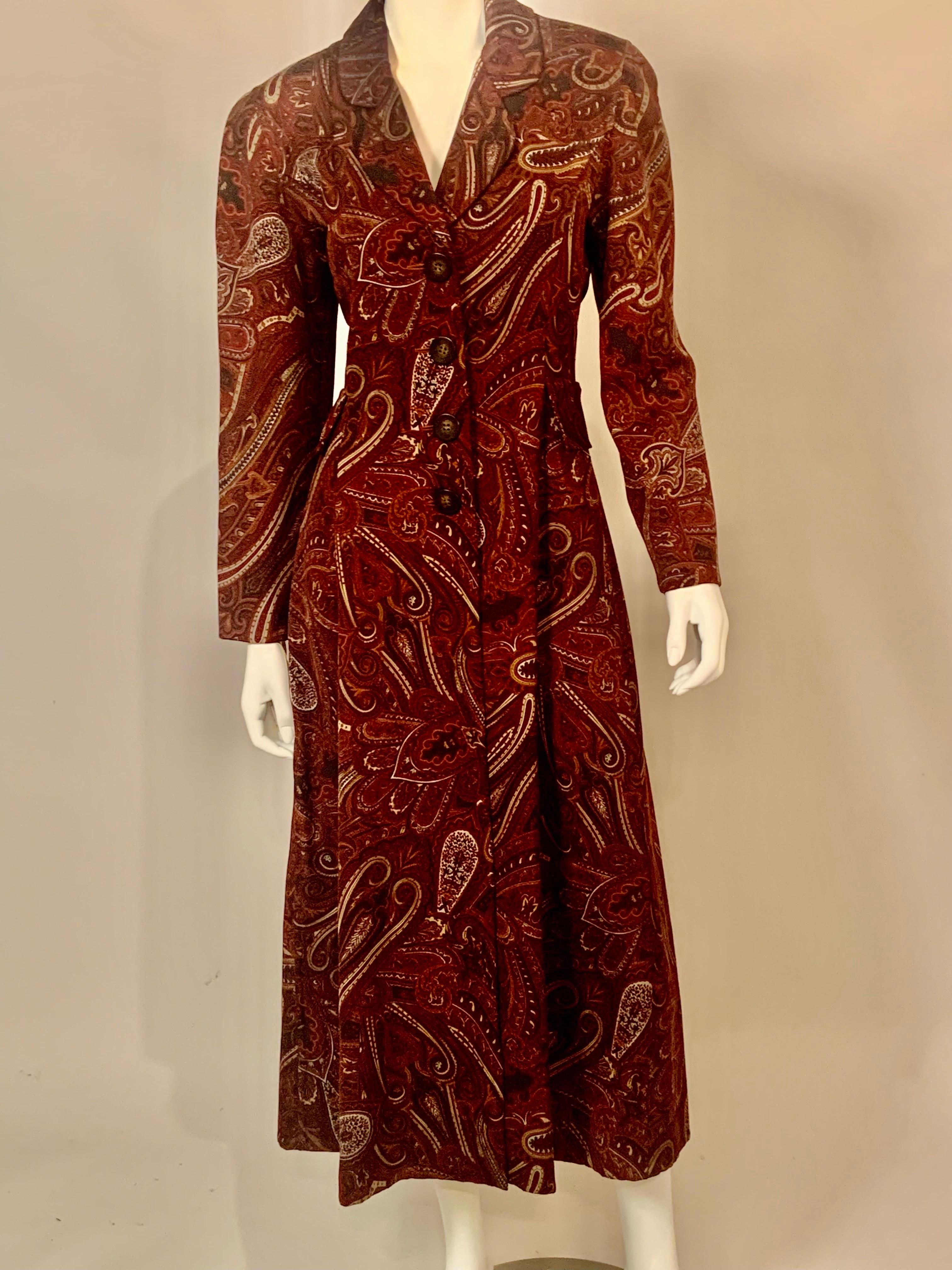 A stunning long red wool paisley coat from Bill Blass has a notched collar and four button closure.  There is a matching neck scarf and the coat is lined in sage green lightweight wool.  It is in excellent condition.
Measurements;   Shoulders 17