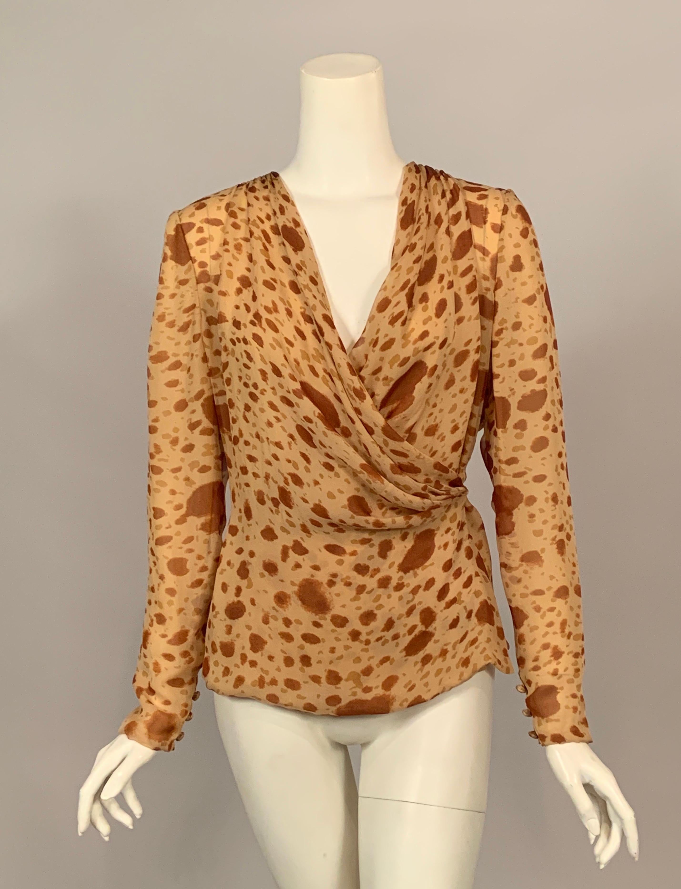 This is a great wrap blouse designed by Bill Blass with a spotted silk chiffon in shades of camel and lined with camel silk chiffon. It has a draped neckline with an interior button and snap closure. The long sleeves have three fabric covered