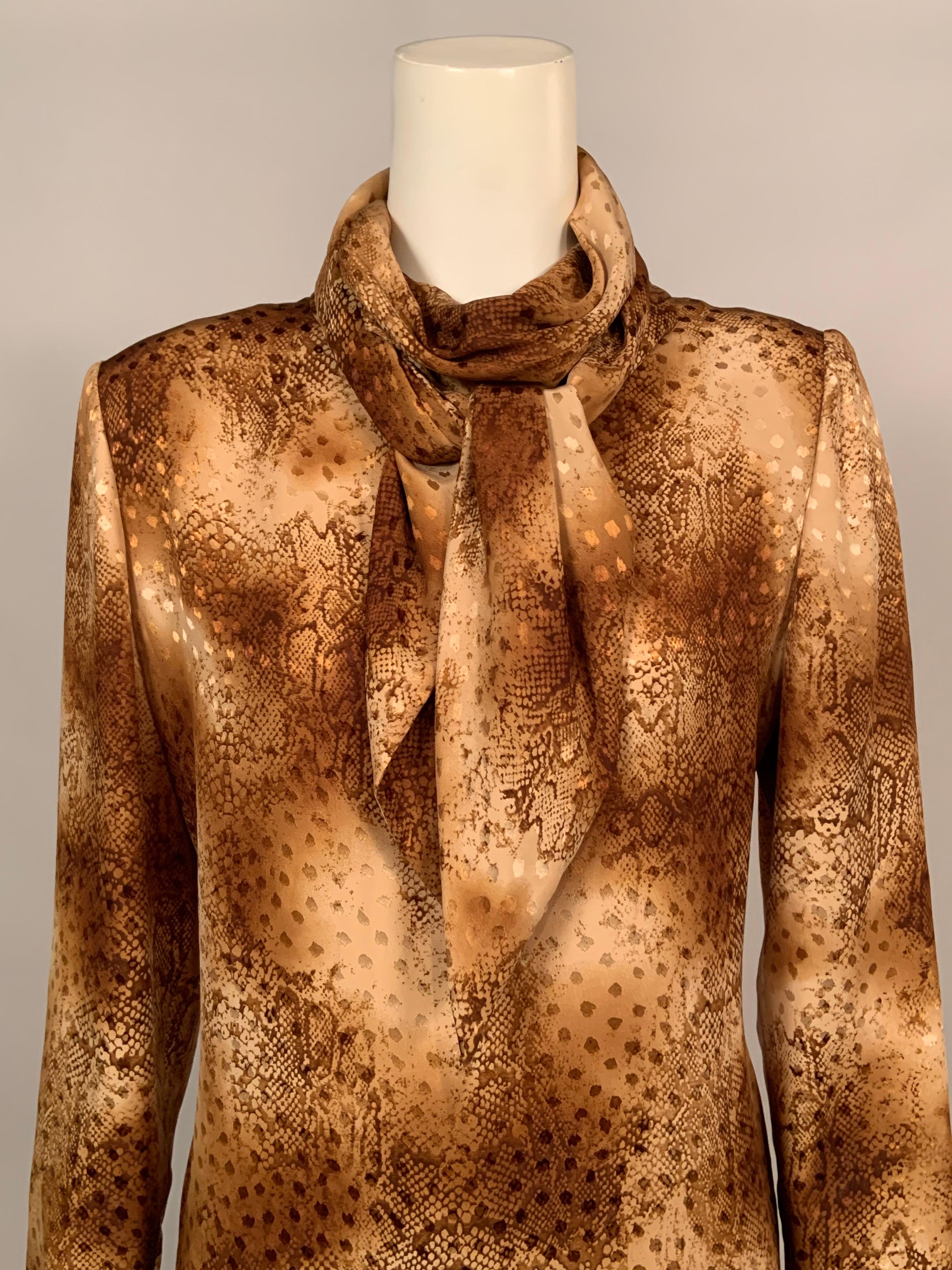 This elegant silk blouse from Bill Blass is made from woven silk that has a spotted  pattern enhanced by a snakeskin print in warm shades of beige and brown.  The blouse has an attached scarf neckline, self covered buttons and loops at the wrist and