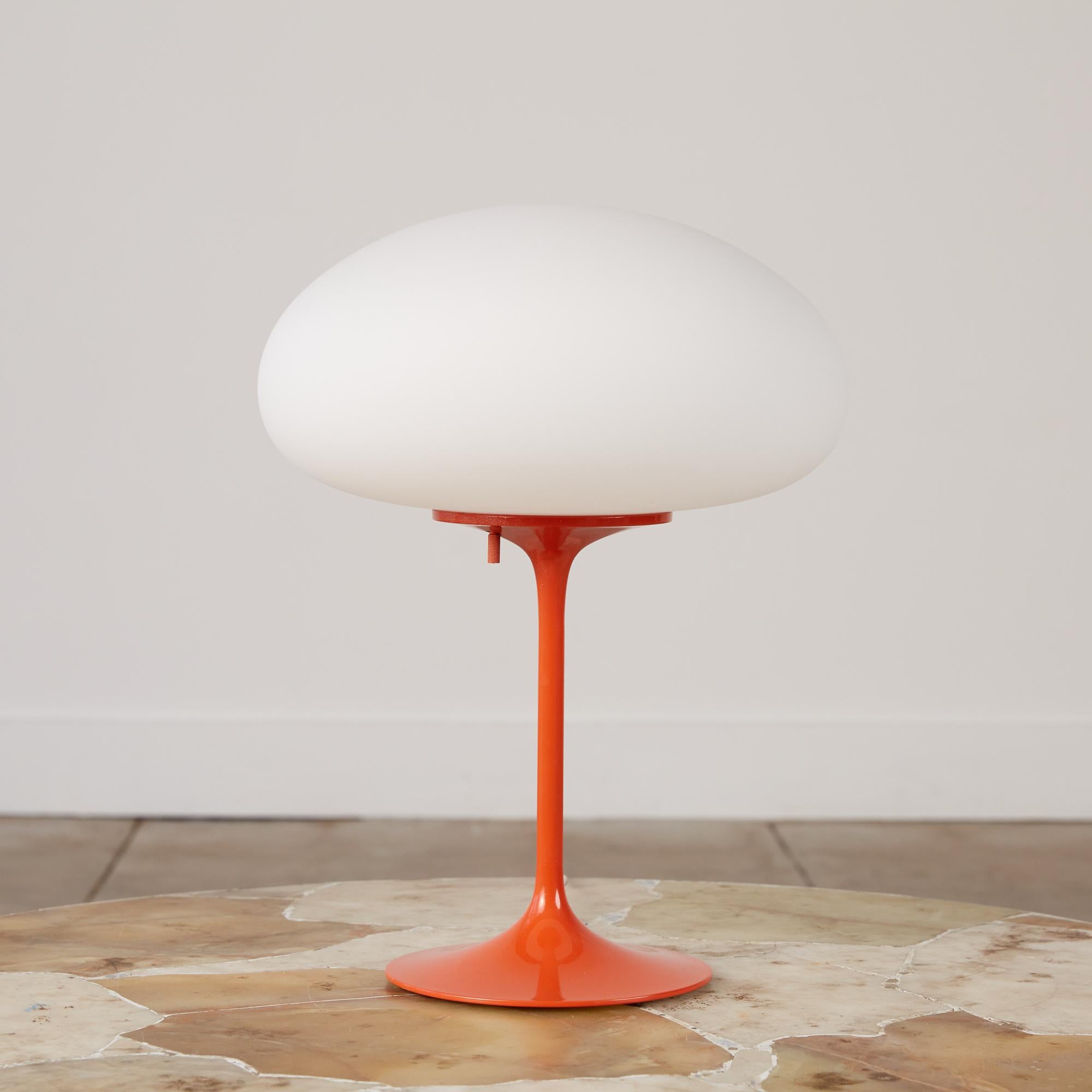 Bill Curry “Mushroom” table lamp for Design Line, USA, c.1960s The lamp features an orange enamel stem and tulip base which supports a frosted glass globe that emits a soft glow when lit. The on and off switch is discreetly situated underneath for