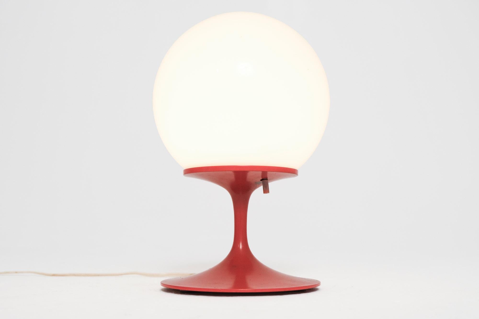 An original Stemlite table lamp designed by Bill Curry for Design Line, USA, circa 1960s. This model features the signature tulip-style cast metal base finished in vibrant red, paired with its original opal glass globe. A seminal piece of American