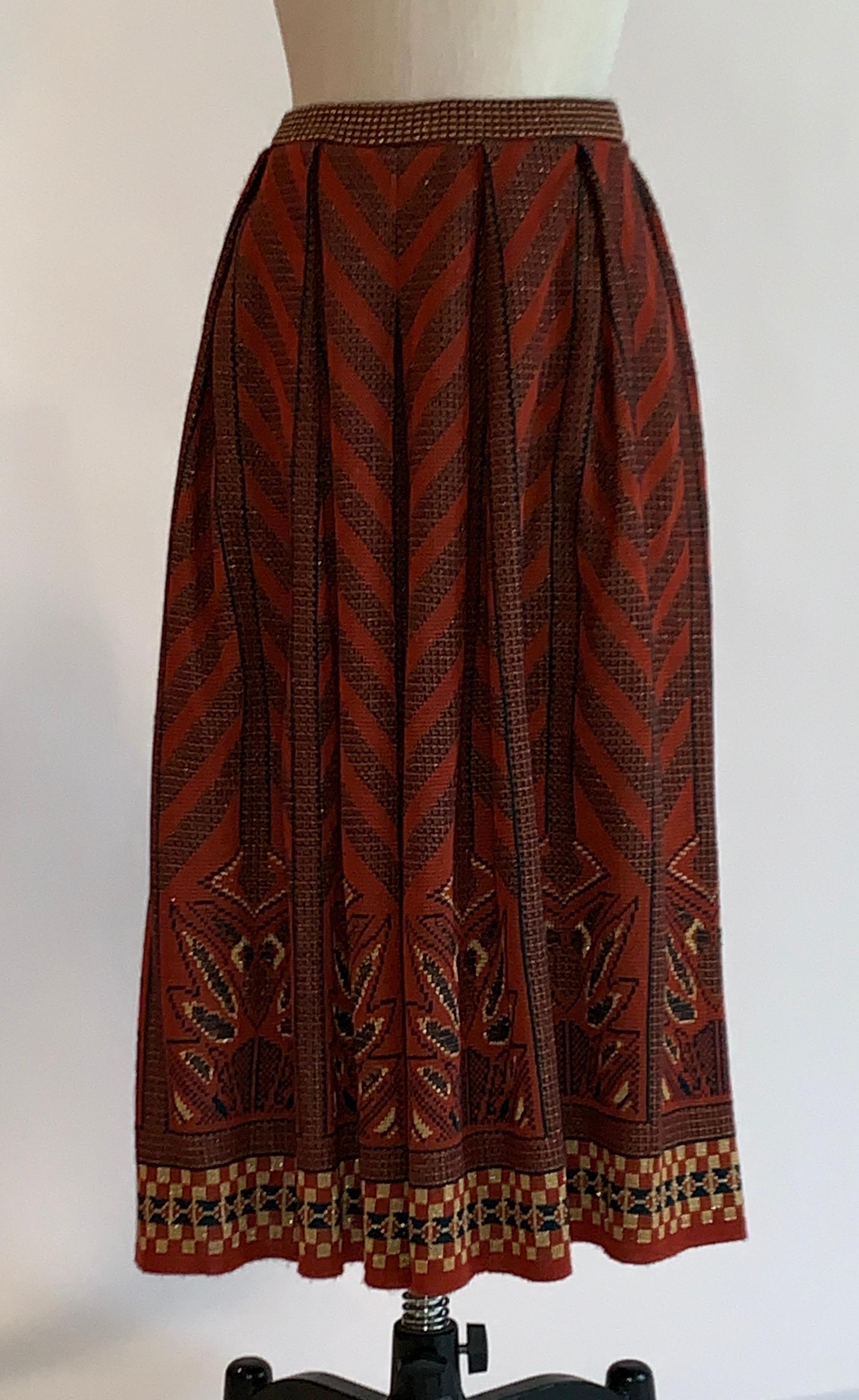 Bill Gibb for Homes and Gardens vintage 1970s knit skirt featuring geometric pattern in shades of maroon, black, metallic gold, and green. Pull on style with elastic waist. 

95% acrylic, 5% metallic.

Made in England. 

Labelled UK size 18