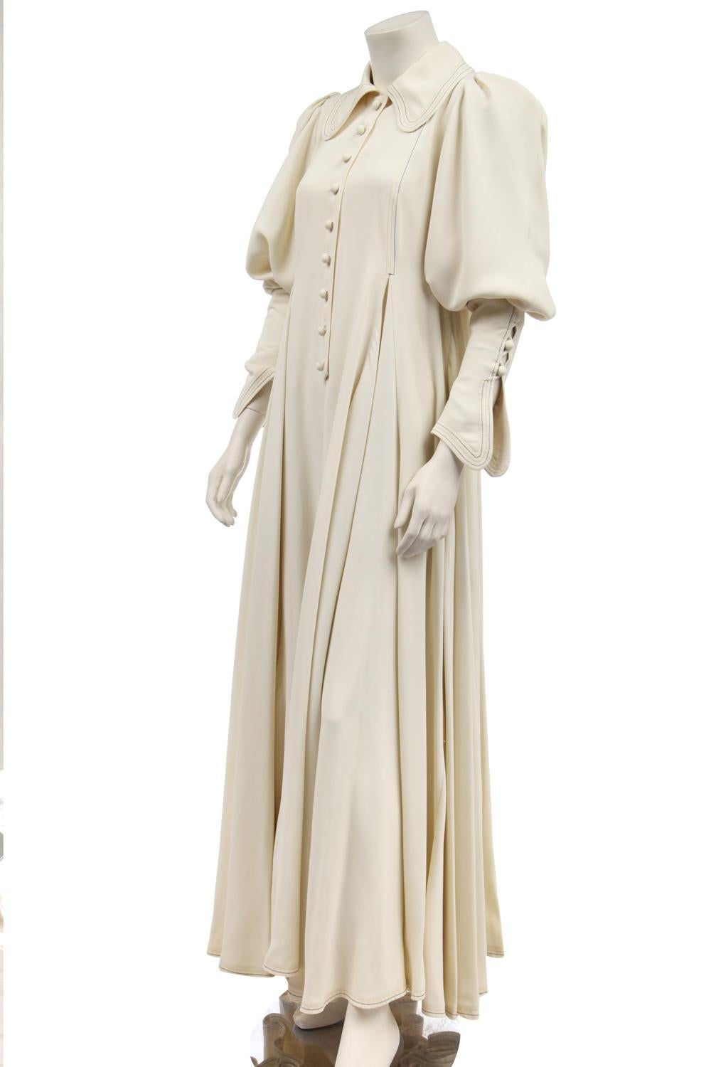 Bill Gibb 1972 Fall/Winter ivory moss crepe evening gown with curved collar and sleeve cuffs, fabric-covered buttons, raglan sleeves, voluminous gored skirt and yellow and black top- stitched detailing. Size UK 12, no fabric tag. In excellent