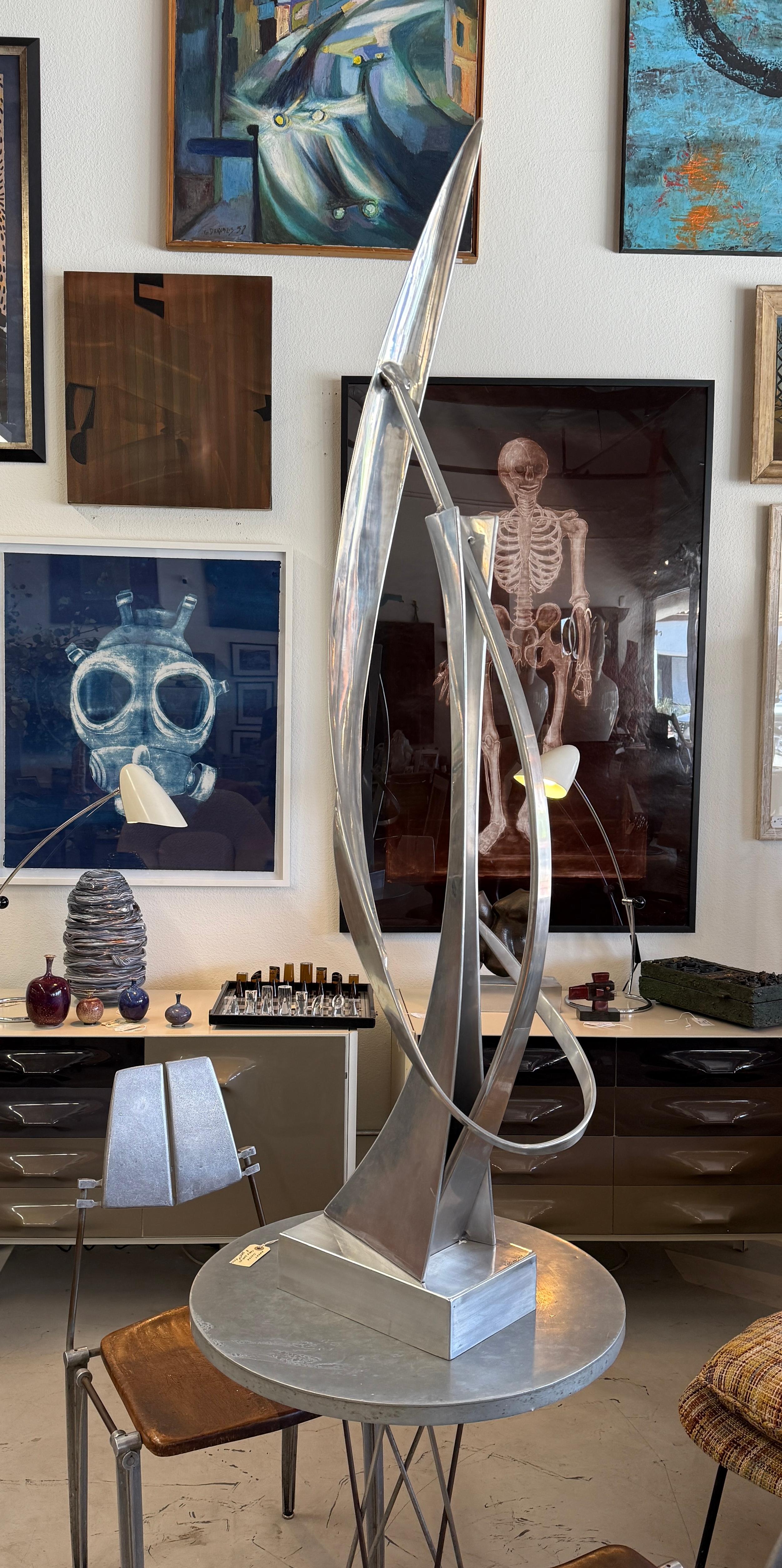A great large aluminum abstract sculpture by the noted artist William Bill Keating. It is signed and dated 1975. Nice size and scale, as this sculpture is solid aluminum it can be used indoors or as a garden sculpture. 
The sculpture is in good
