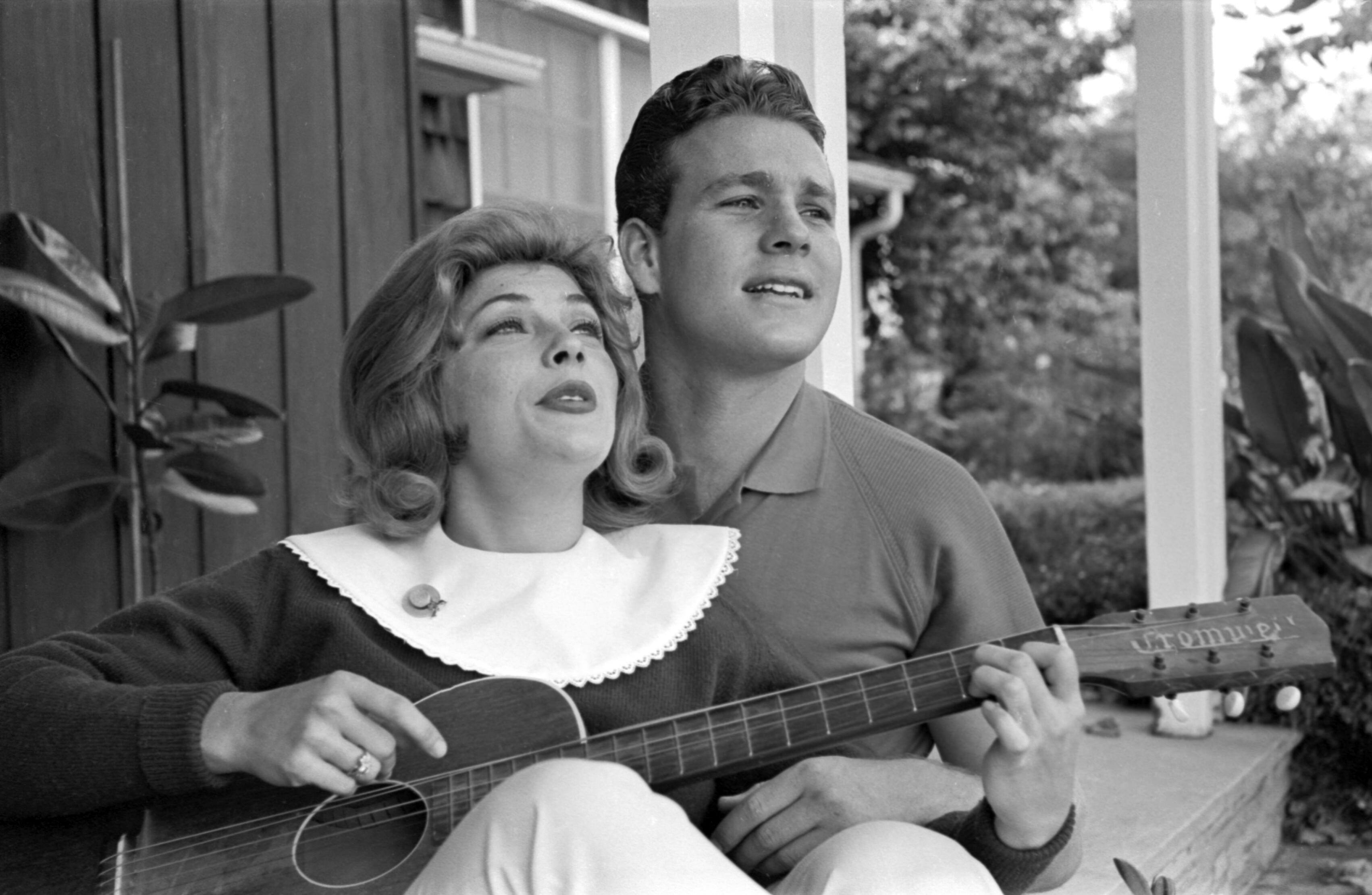 Bill Kobrin Portrait Photograph - Ryan O'Neal and Joanna Moore Playing Guitar at Home Fine Art Print
