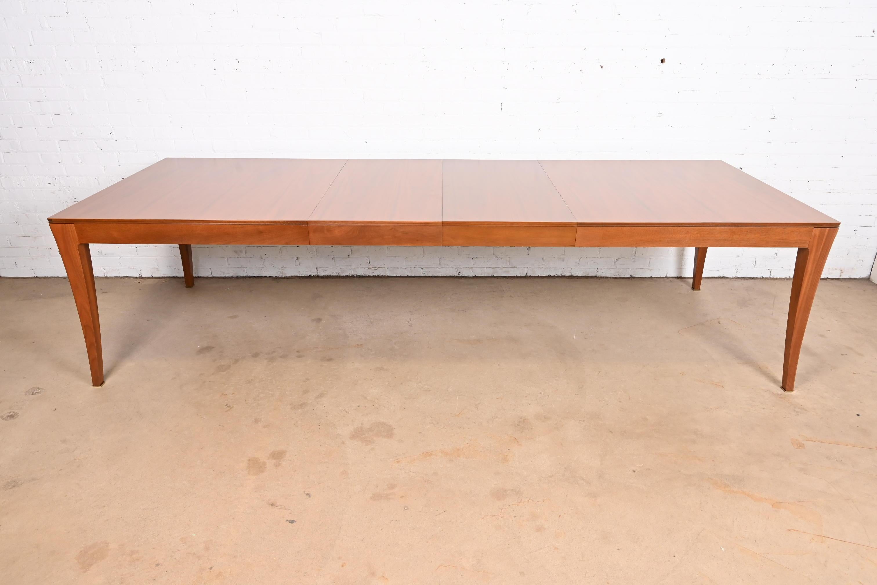 A gorgeous Modern extension dining table

By Bill Sofield for Baker Furniture

USA, Early 21st Century

Book-matched walnut, with brass-capped feet.

Measures: 78