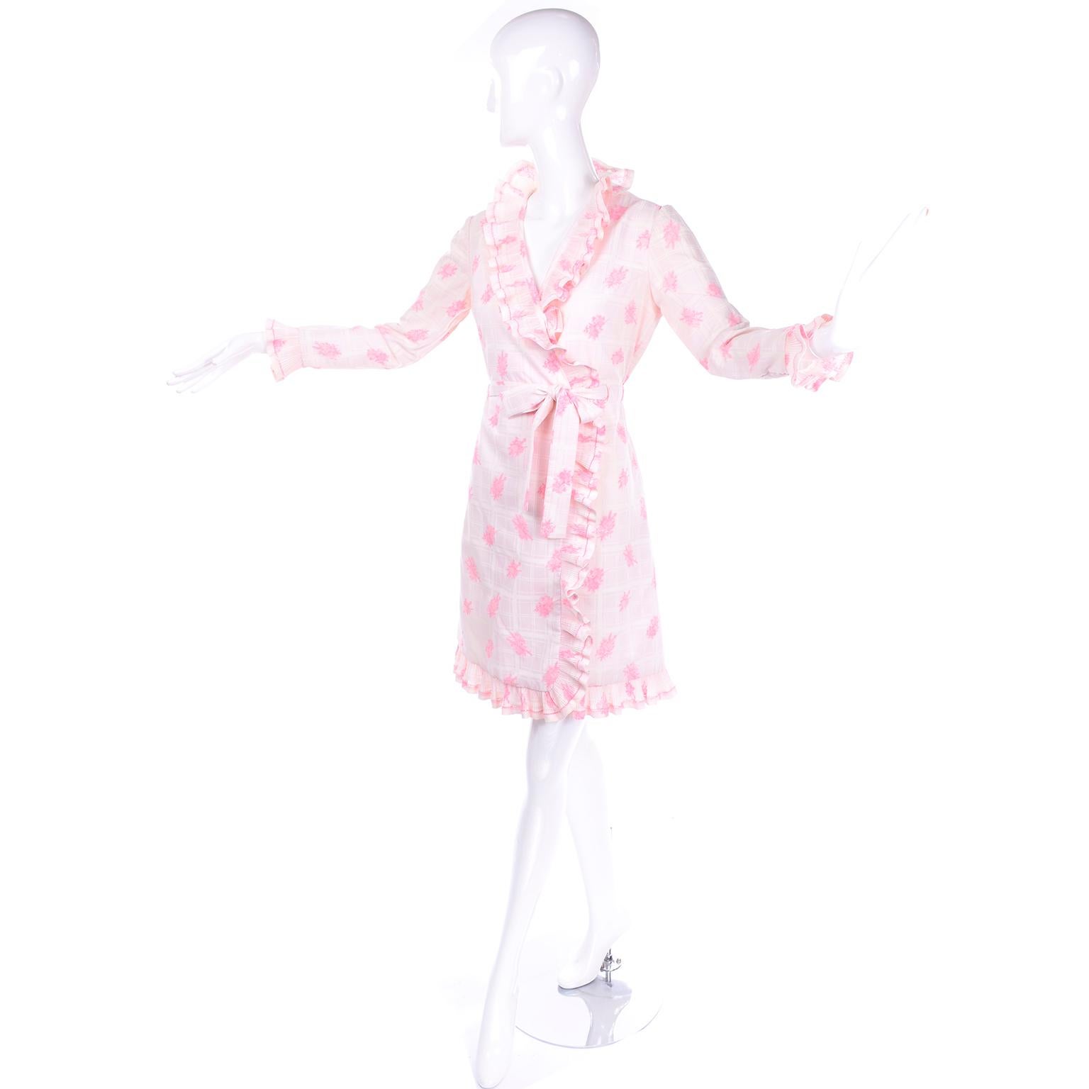 This is such a pretty vintage cotton dress from Bill Tice. The dress is made in a pink toile print on white and cream windowpane plaid.  This wrap style dress has pleated ruffles and it has its original belt.  We estimate it to fit a modern day size