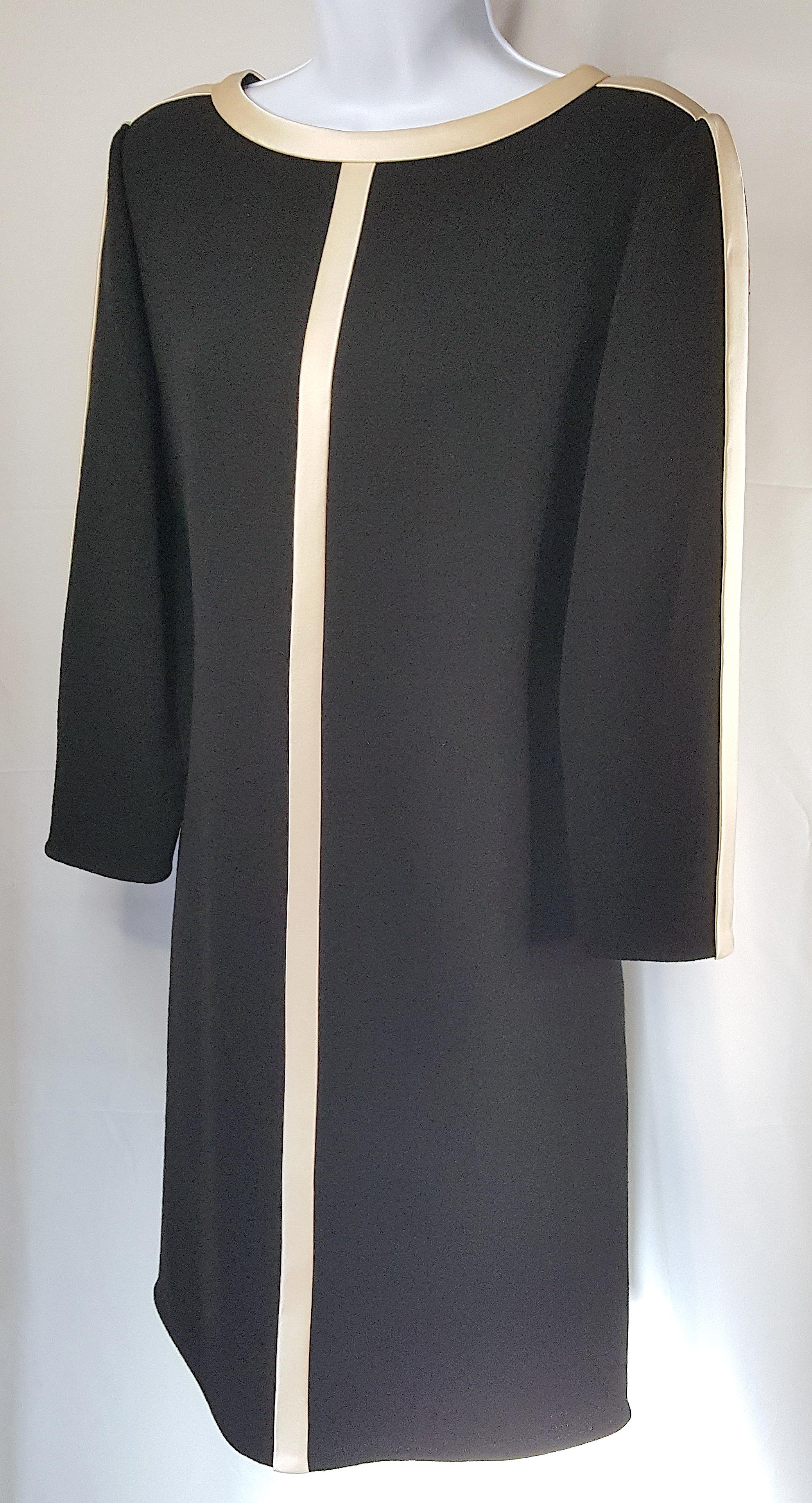Around 1970 when he introduced his eponymous brand after becoming a leading couture fashion designer among New York City society, American Bill Blass created this sleek tuxedo-like ecru-satin-trimmed long-sleeve black wool crepe shift dress. The