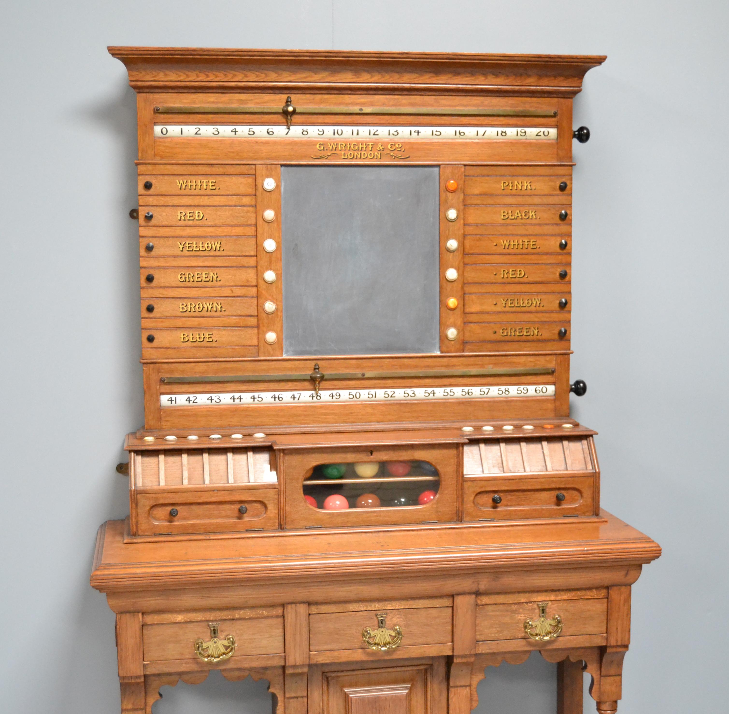 A solid oak free standing scoring cabinet by George Wright of London, circa 1890.

A country house cabinet to score billiards, snooker and life POOL, central slate panel flanked by revolving number bars and lettered life POOL panels with inlaid