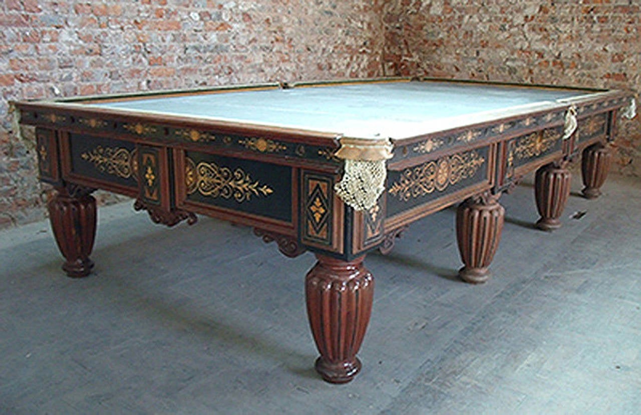 A superb decorative full size carved and inlaid billiard table by Cox & Yeman of London, circa 1860, standing on eight handsome gadrooned legs the side frames and cushions are adorned with intricate box wood and Thuya burr inlays.
The table is