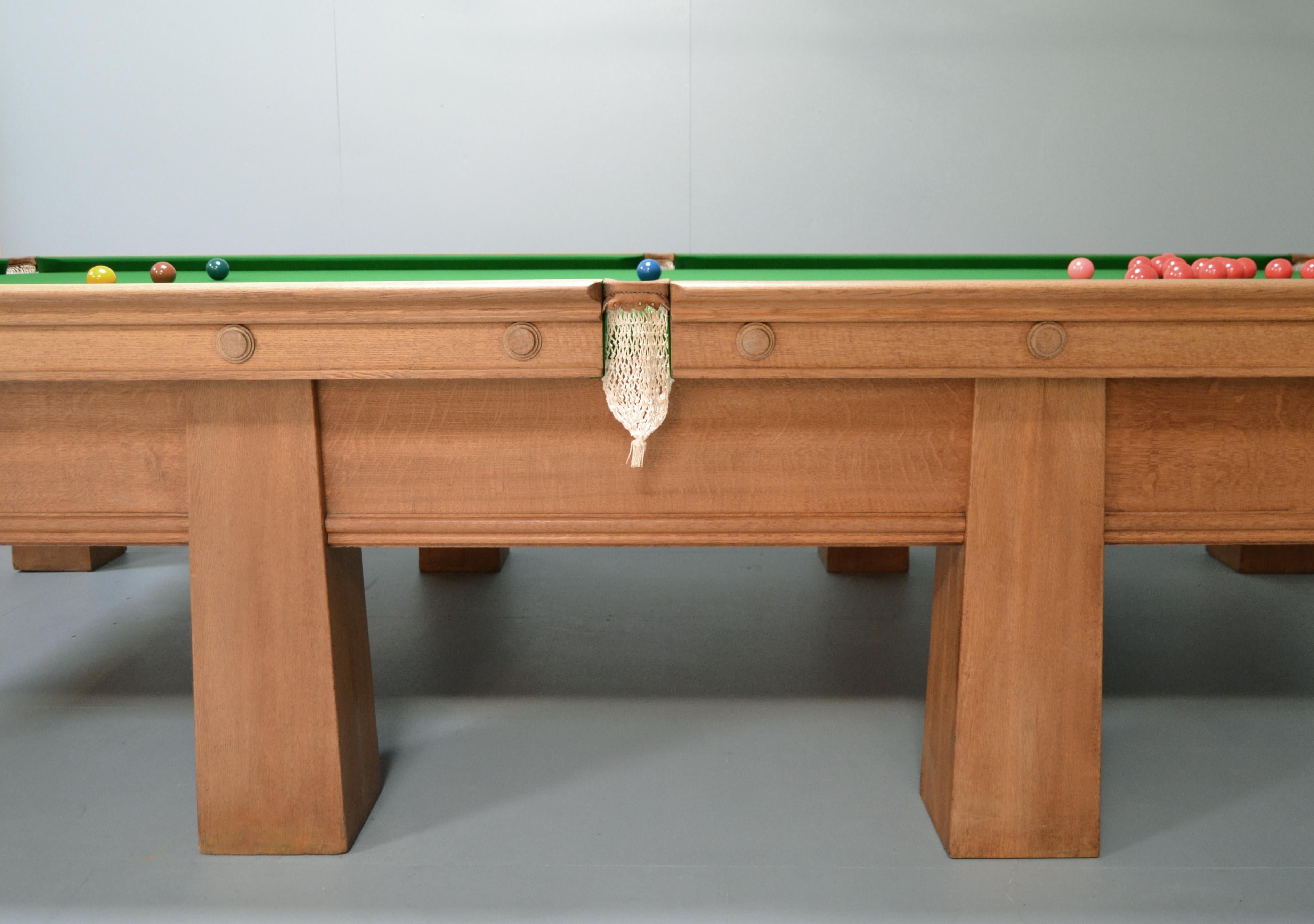 A wonderful Arts & Crafts billiard or snooker table in solid oak by Burroughes & Watts of London, this beautiful table has great presence.

Standing on eight gargantuan tapering legs, all of the frame fixings are internal so the line of the leg is