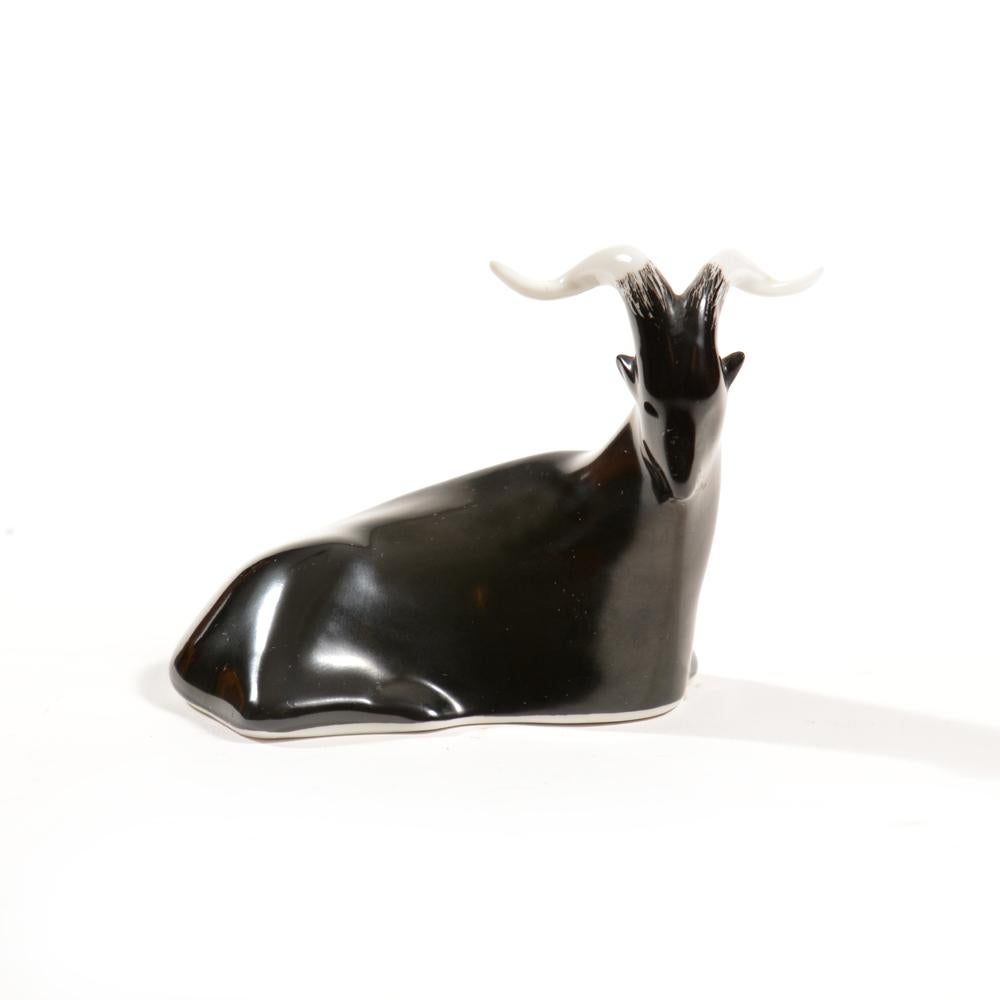 Small, but elegant. This beautiful porcelain sculpture shows a billy goat laying down. Black goat with white horns and beautiful details with almost an abstract features so typical for the midcentury era of sculptures. The sculpture was produced by